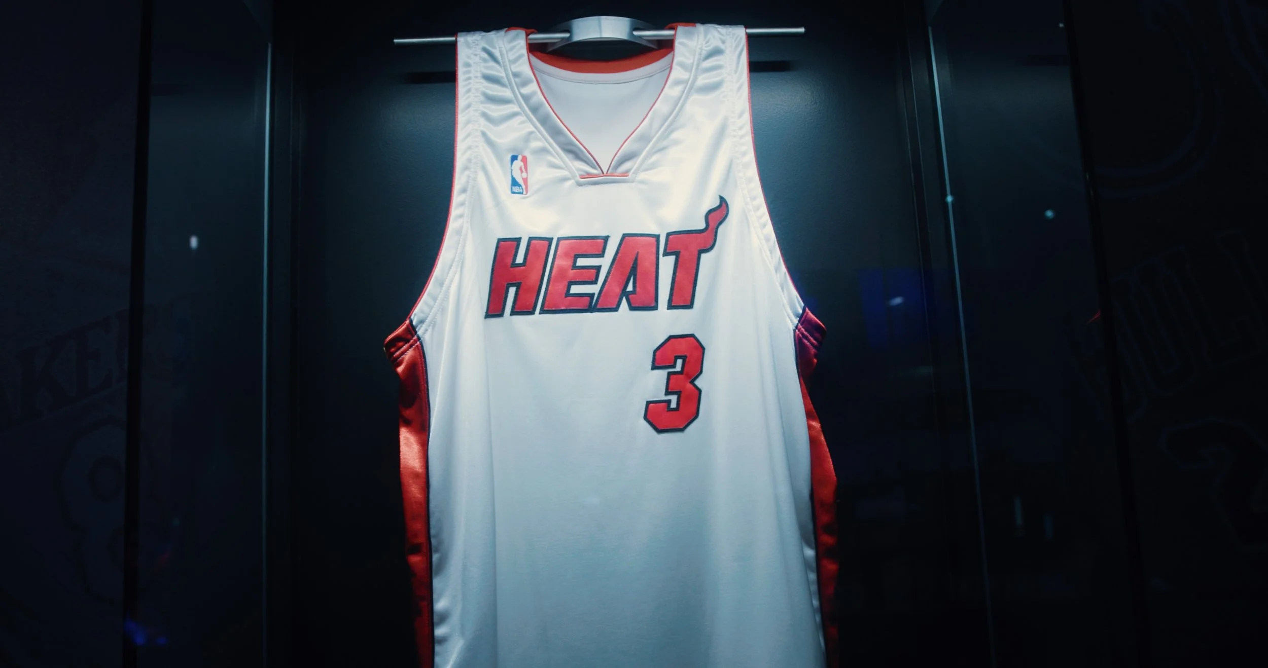 Miami Heat basketball jersey with the number 3, displayed in a showcase.