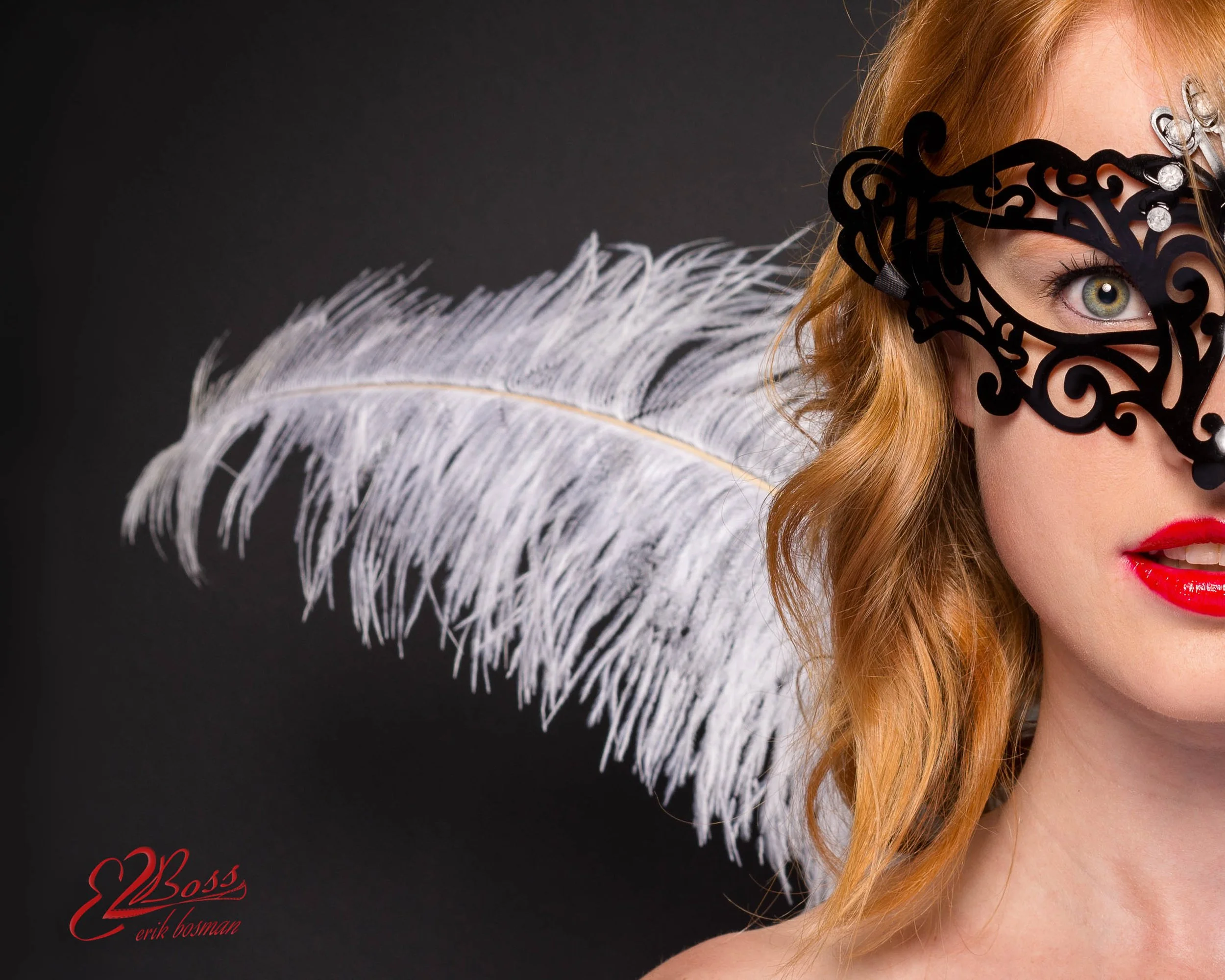 A woman with red hair and red lipstick wearing an elaborate black mask and a white feathered accessory against a black background, with the signature of Erik Bosman in red at the bottom left.