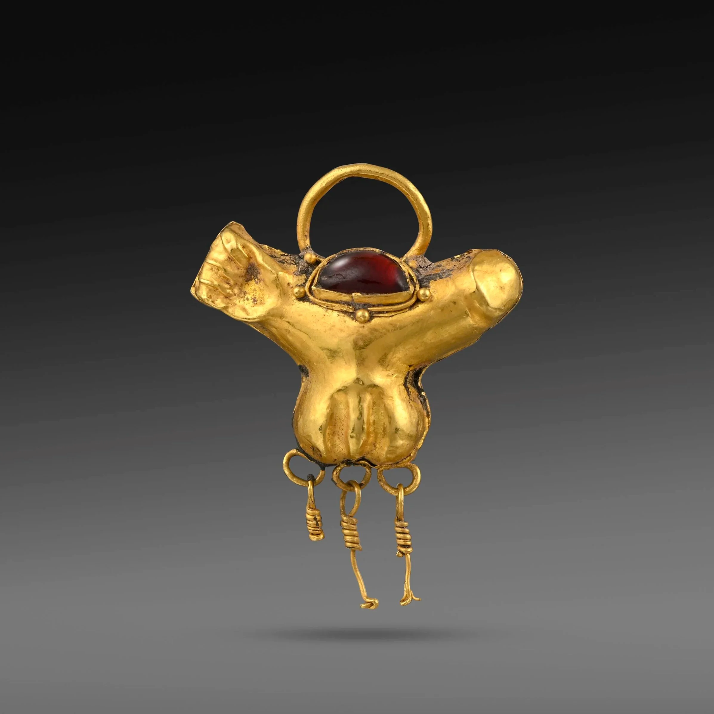 Gold pendant in the form of a penis set with a tear shaped garnet