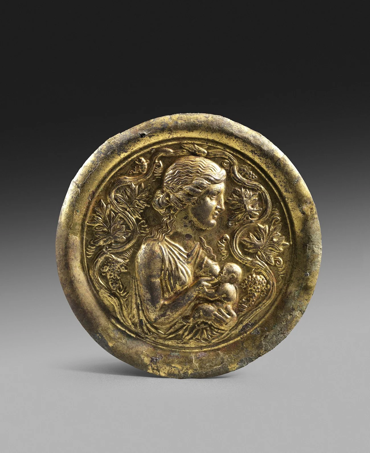 Hellenistic gilt silver mirror-case and mirror with Ino and the infant Dionysus
Graeco-Roman, circa 1st century BC-1st century AD, diameter: 10 cm, Private collection UK (N.E.), acquired 1950s-1960s and thence by descent