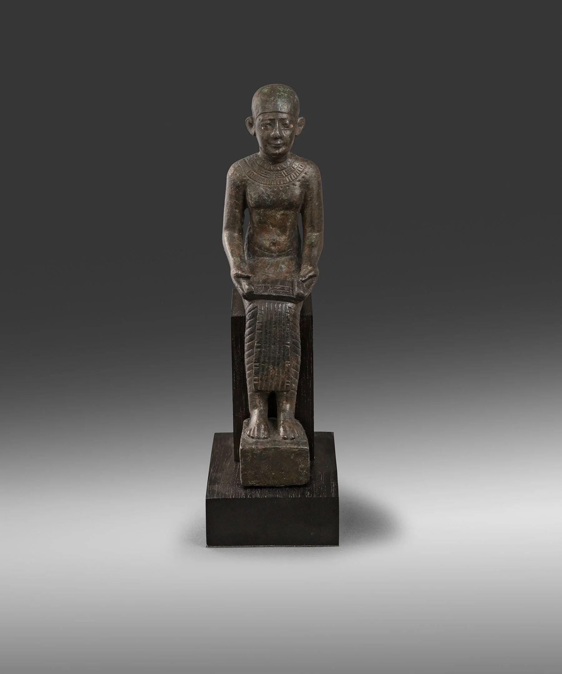Egyptian bronze figure of Imhotep
Late Dynastic Period, 26th-30th Dynasty, 664-343 BC
Height: 15.2 cm, Collection of Aslan Leon Cattaui (1890-1987), Switzerland, received as a gift from the Automobile Club of Egypt in 1954 and thence by descent
