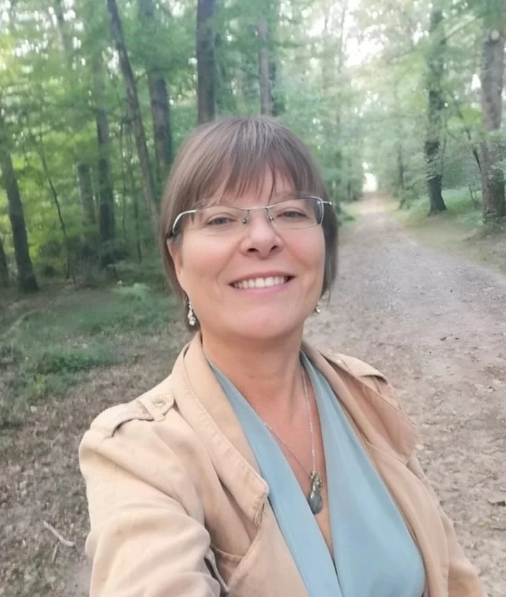 Femme souriante prenant un selfie dans une forêt verdoyante