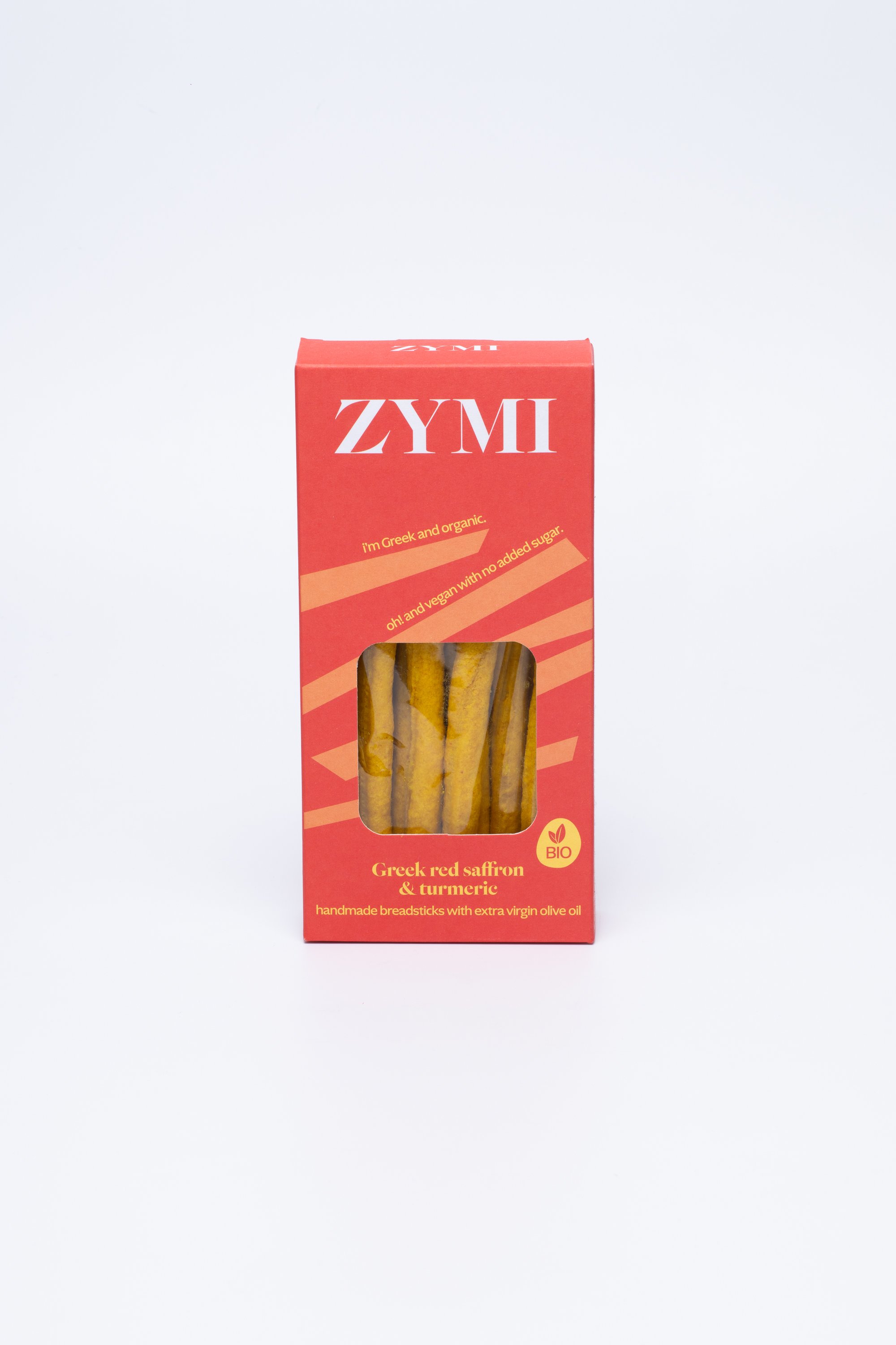 ZYMI product box in light red colour with light colour lines, showing turmeric & greek red saffron breadsticks through a window cutout.