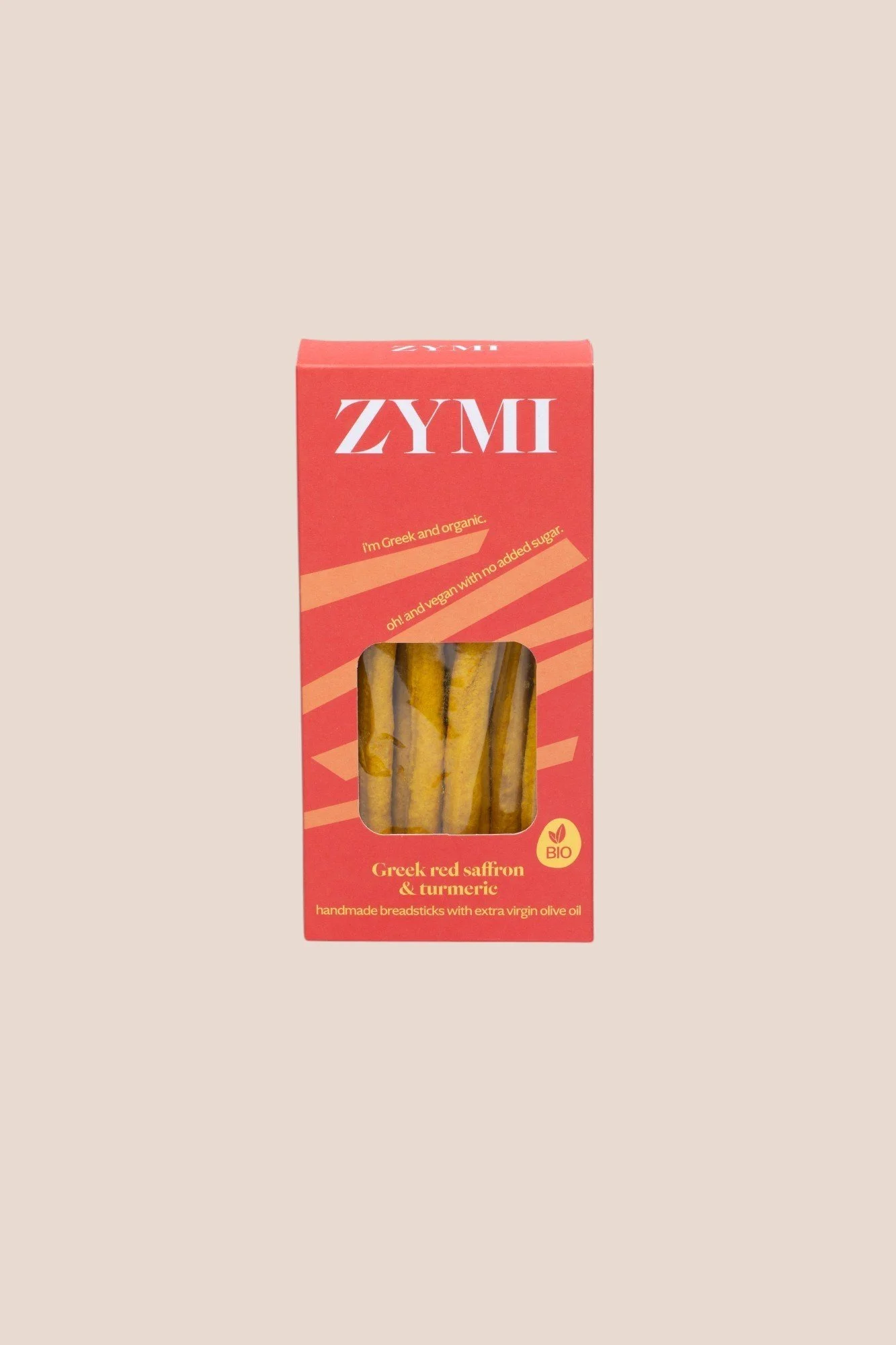 A red box of ZyMi brand Greek red saffron and turmeric breadsticks with a window showing the breadsticks inside. The box has text indicating it is Greek, vegan, and organic, with added virgin olive oil.