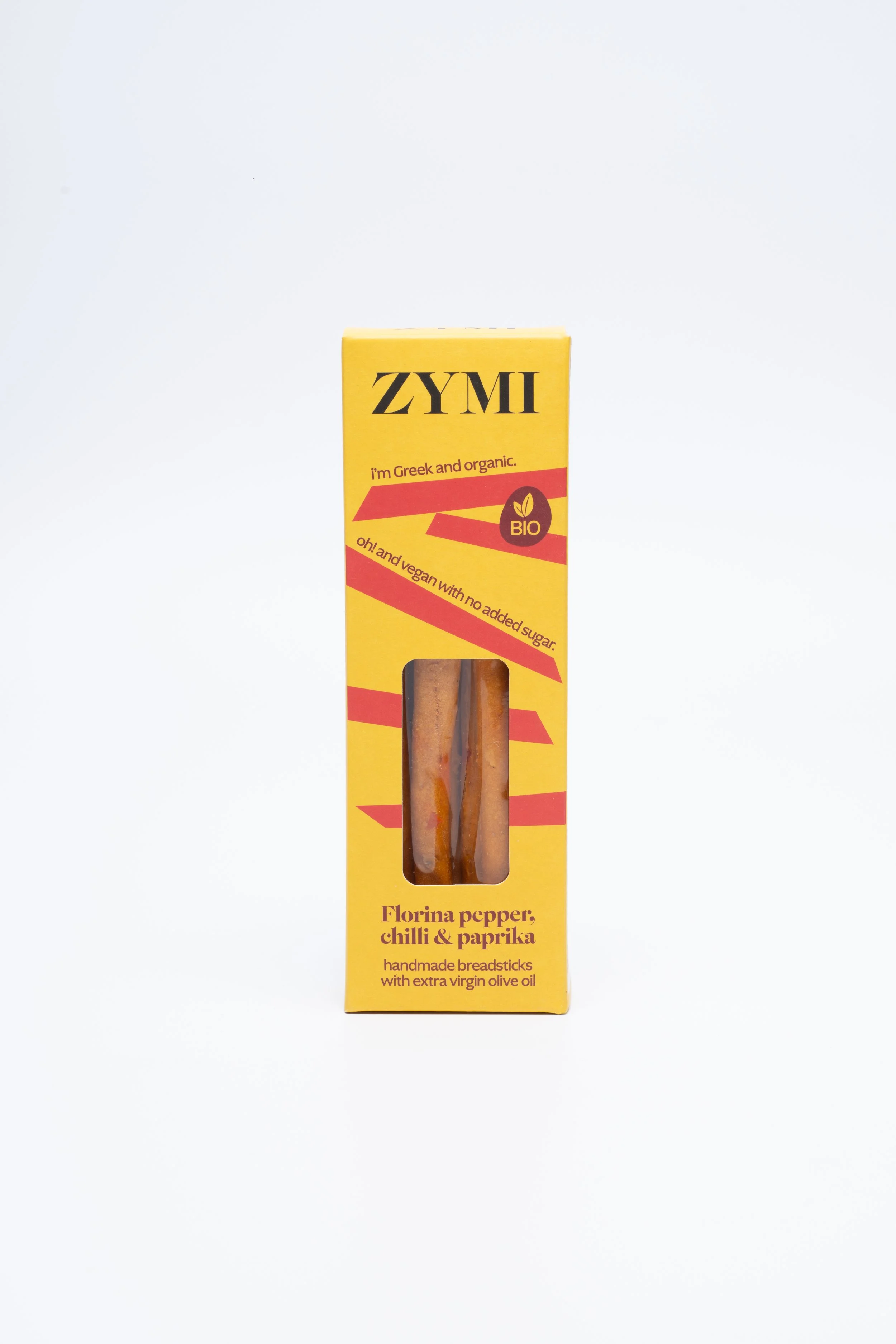 ZYMI product box in bright yellow colour with red lines, showing florina pepper, chili & paprika breadsticks through a window cutout.