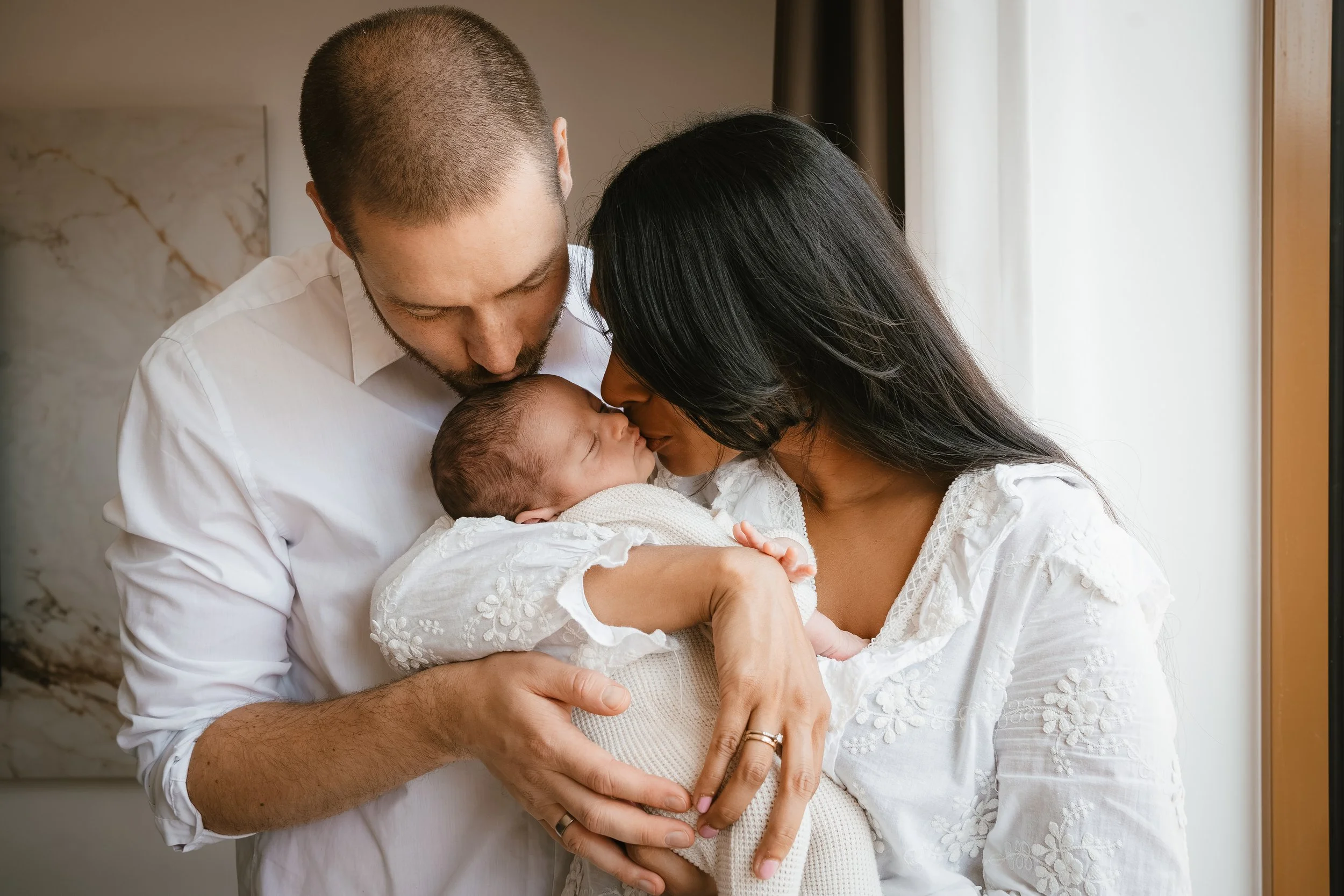 Newbornshoot Dronten, ouders met hun baby in een doek