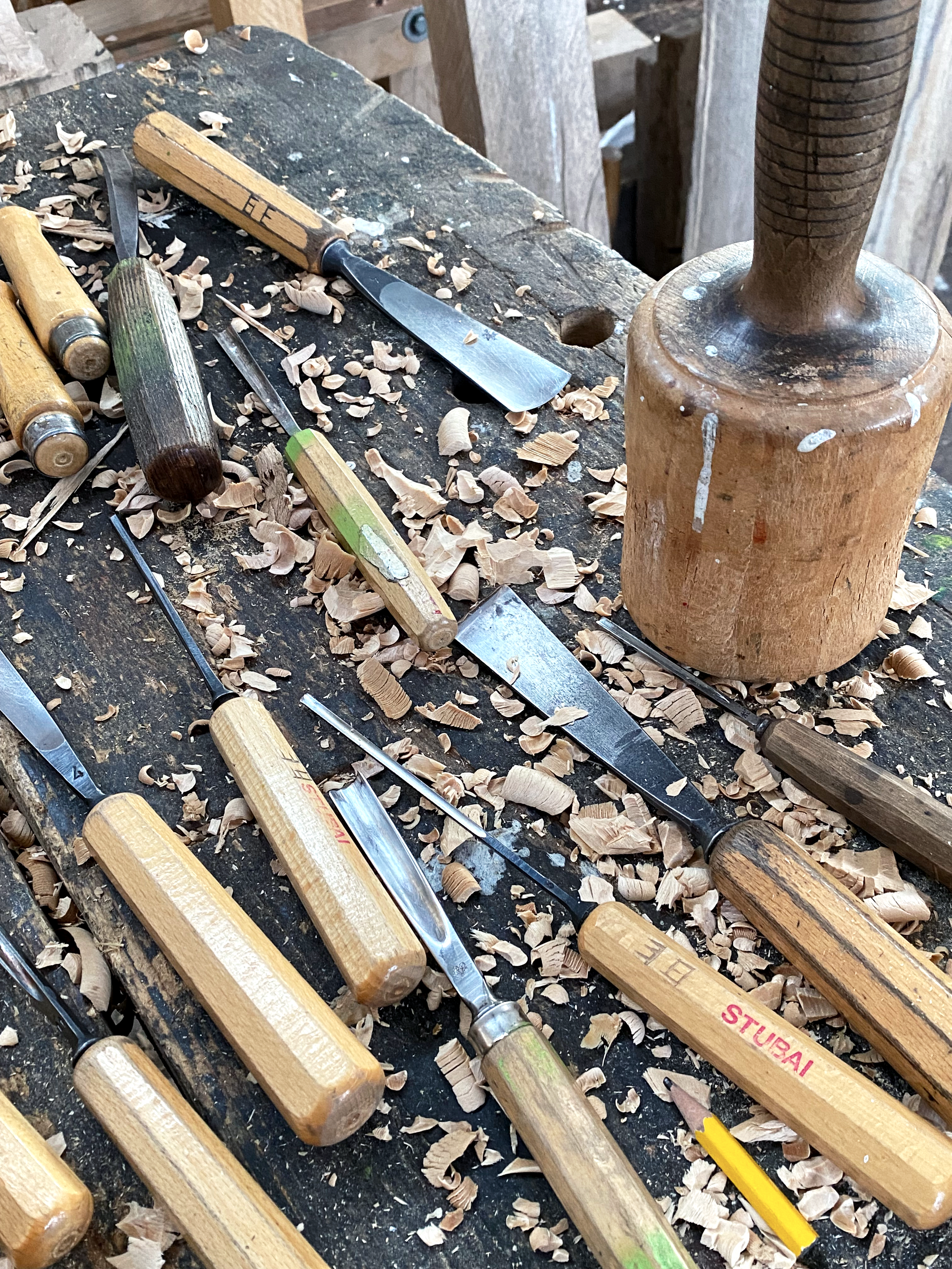 Schnitzwerkzeuge auf einer Holzwerkbank mit Holzspänen