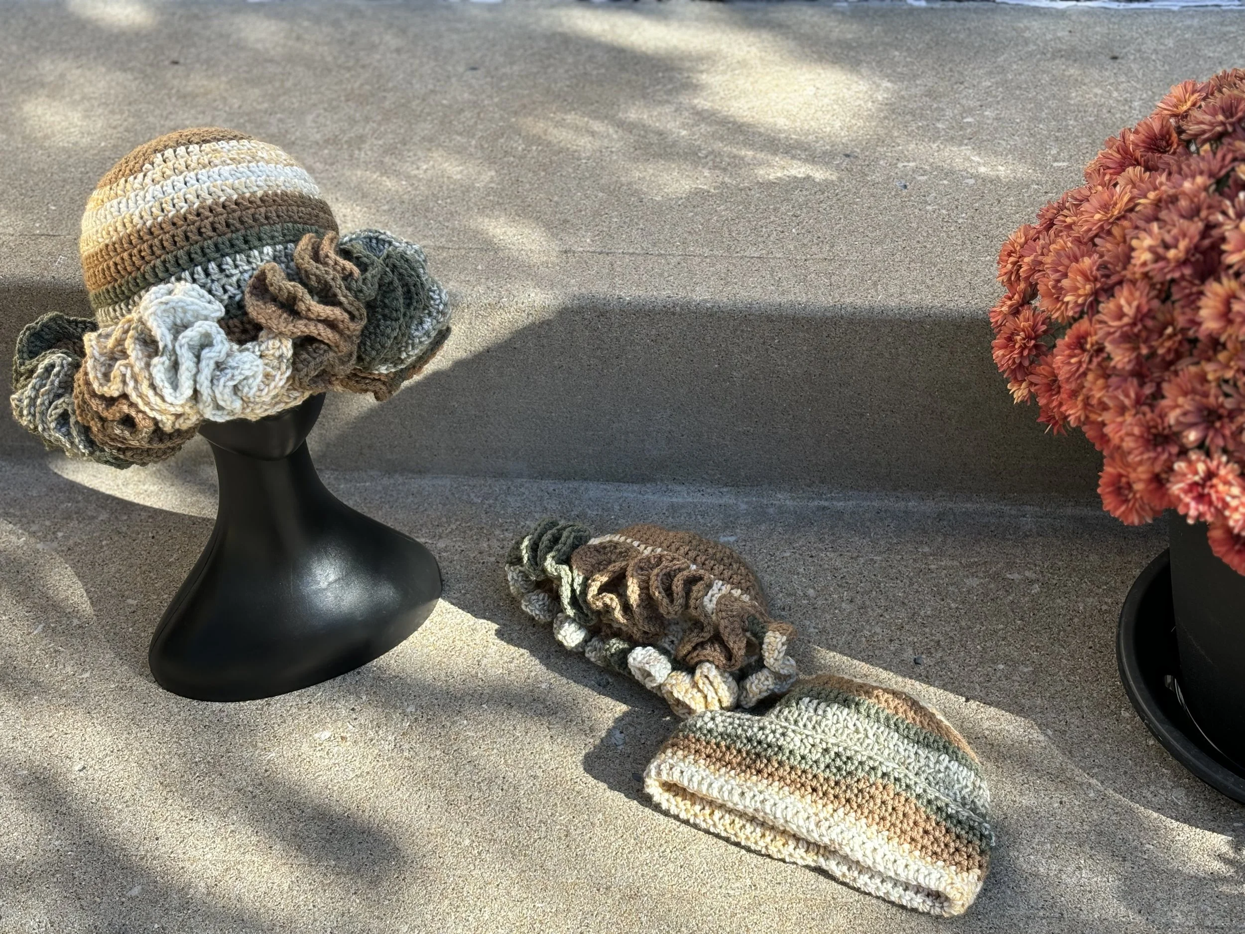 Crochet hat and scarf set on display with flowers
