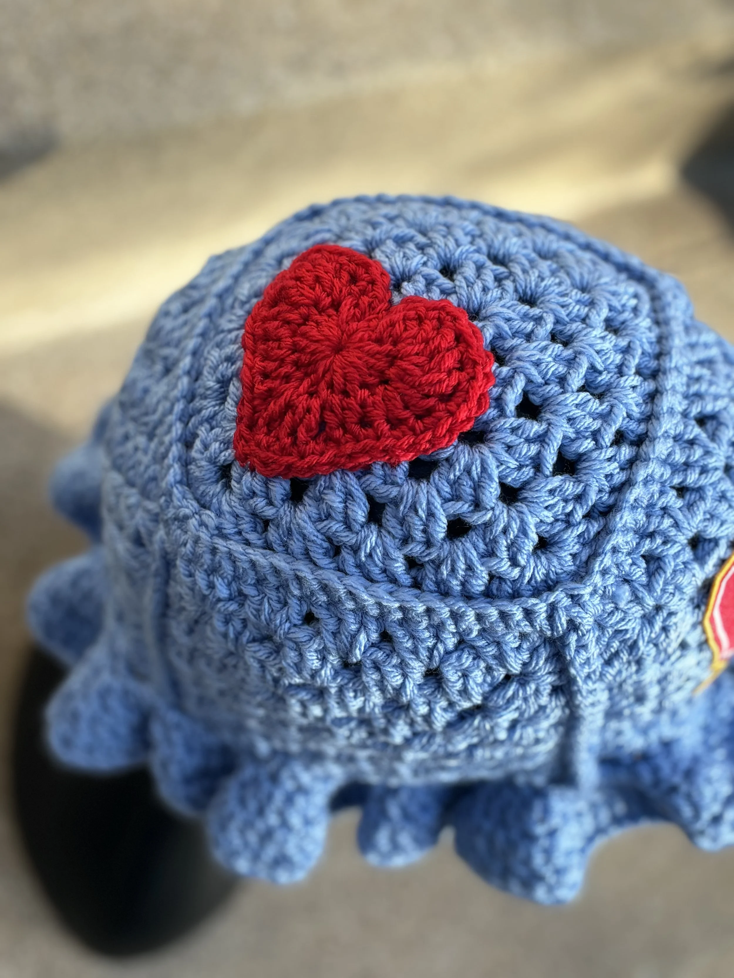 Crocheted blue hat with red heart applique on top