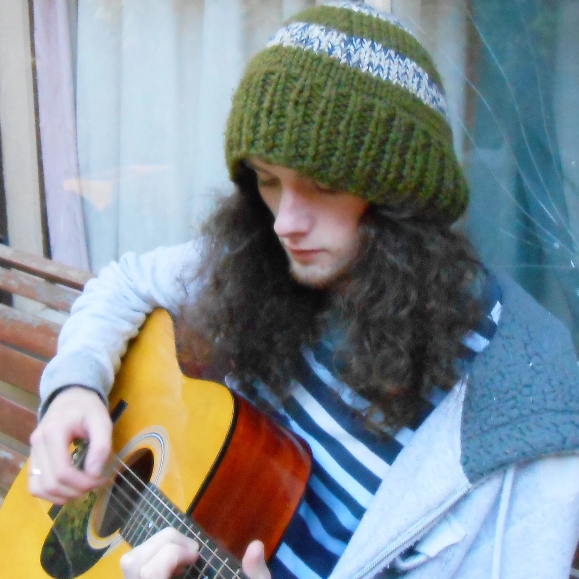 Cale Anderson playing his acoustic guitar.