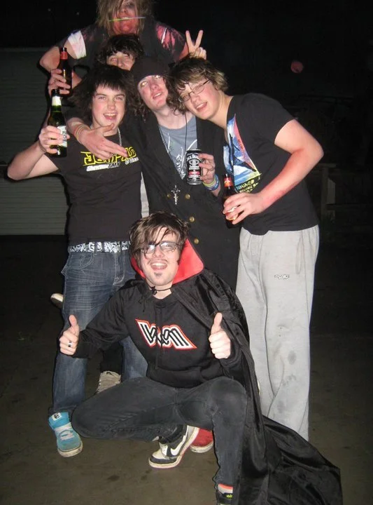 Group of six young people celebrating at a party, some holding drinks, with smiling and cheerful expressions.