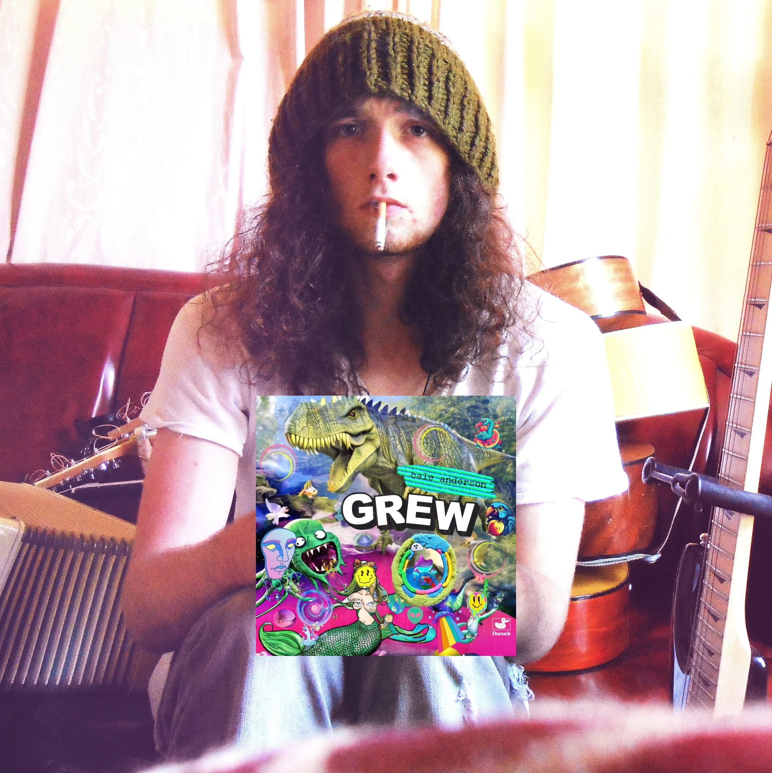 A person with long curly hair wearing a green knit hat is sitting in a room with musical instruments, holding a colorful book titled "Grew" by Cale Anderson, with a cigarette in their mouth.