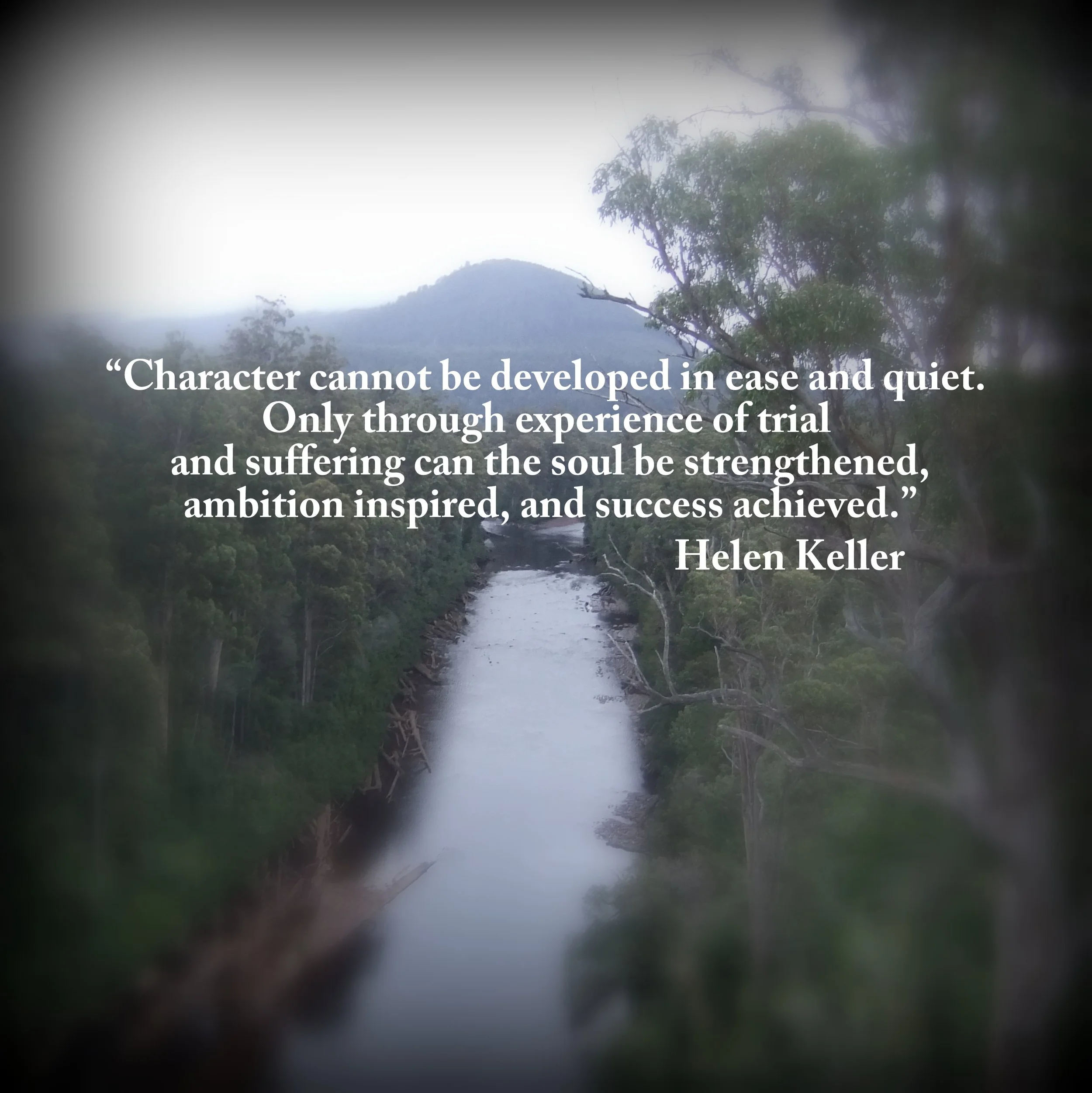 A quiet river flowing through a lush green forest with mountains in the background, overlaid with a quote about character and experience by Helen Keller.