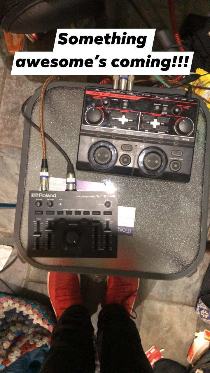 DJ equipment on a black table, including a Roland VT-4 voice transformer and a DJ controller, with a person wearing red sneakers standing below. Text overlay says, 'Something awesome's coming!!!'