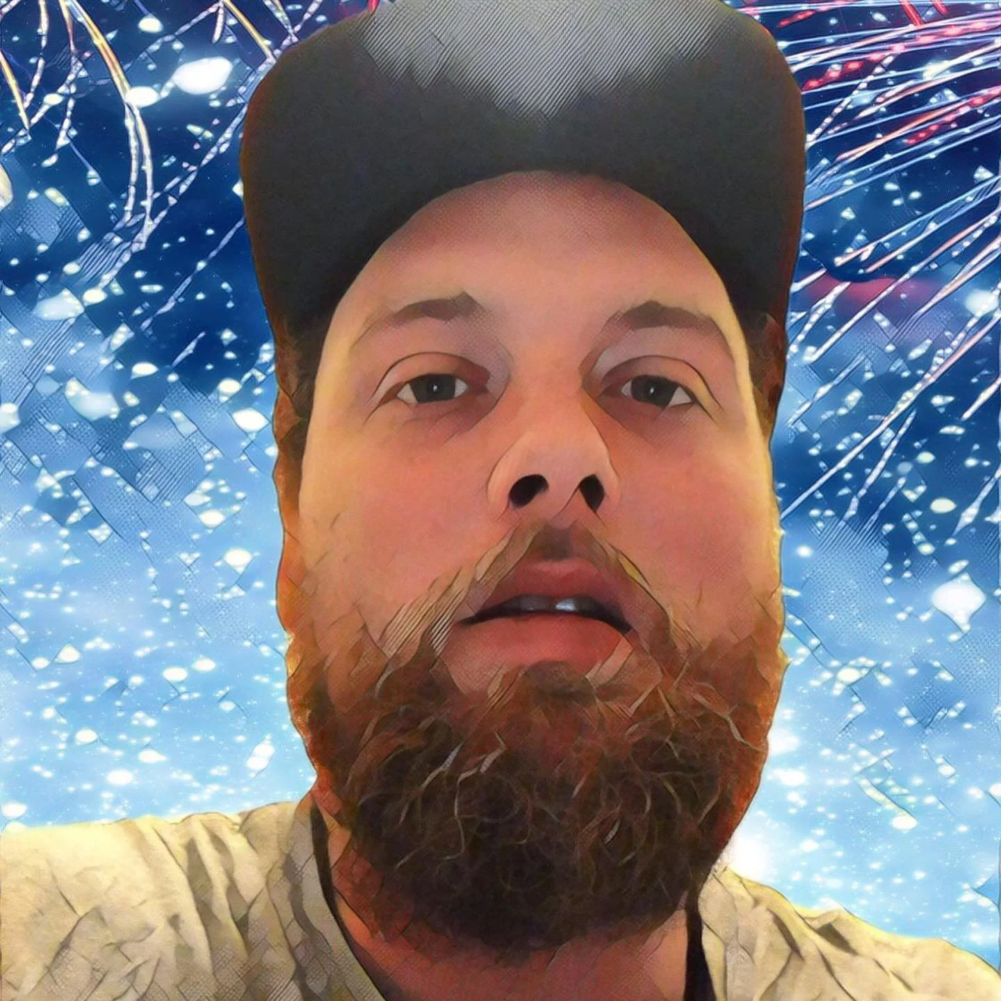 A close-up selfie of a man with a beard, wearing a cap, against a background of sparkler fireworks.
