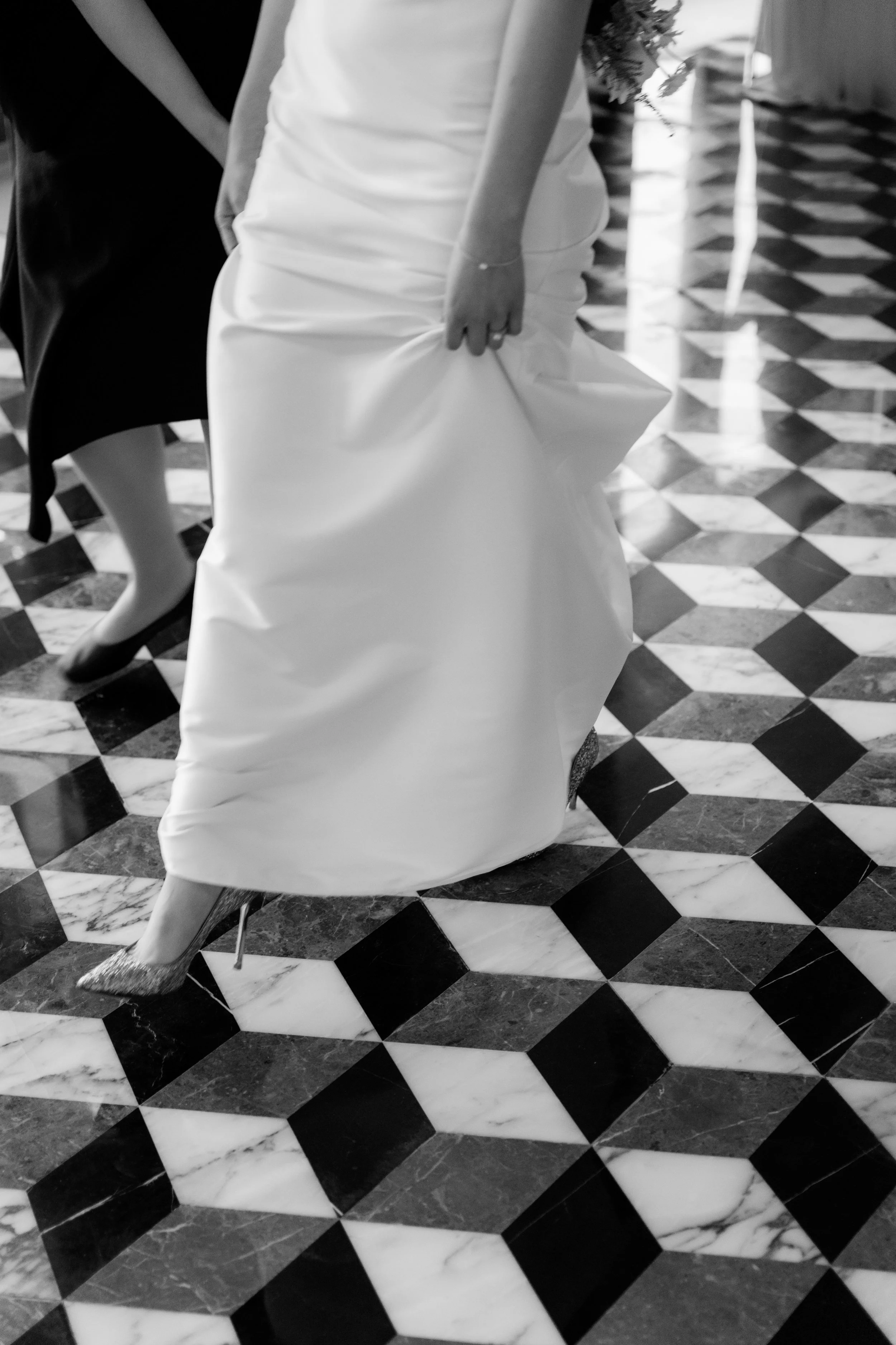 Bride and groom celebrating at a reception with a bouquet and champagne bottles on the counter.