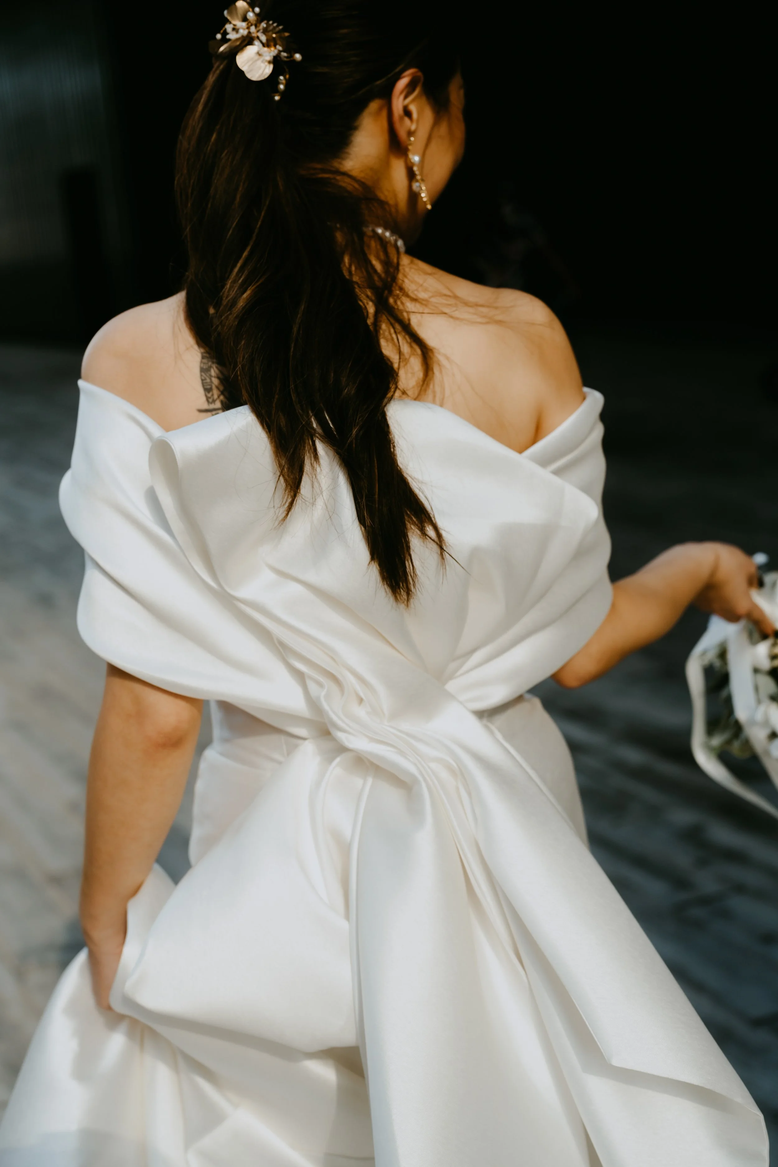 Woman wearing a red hat and red dress, with long brown hair, touching the brim of the hat with her left hand.