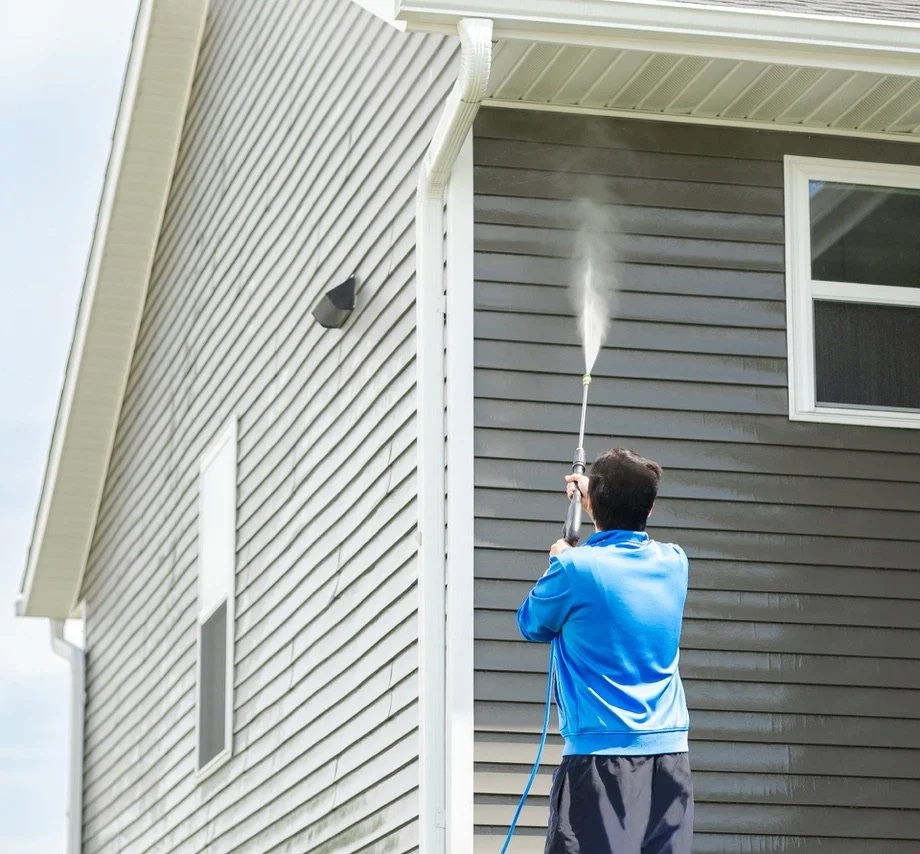 Professional pressure washing of a paved driveway, effectively removing dirt and grime to restore the surface’s original appearance, showcasing Titan Pressure Pros' expert exterior cleaning services.