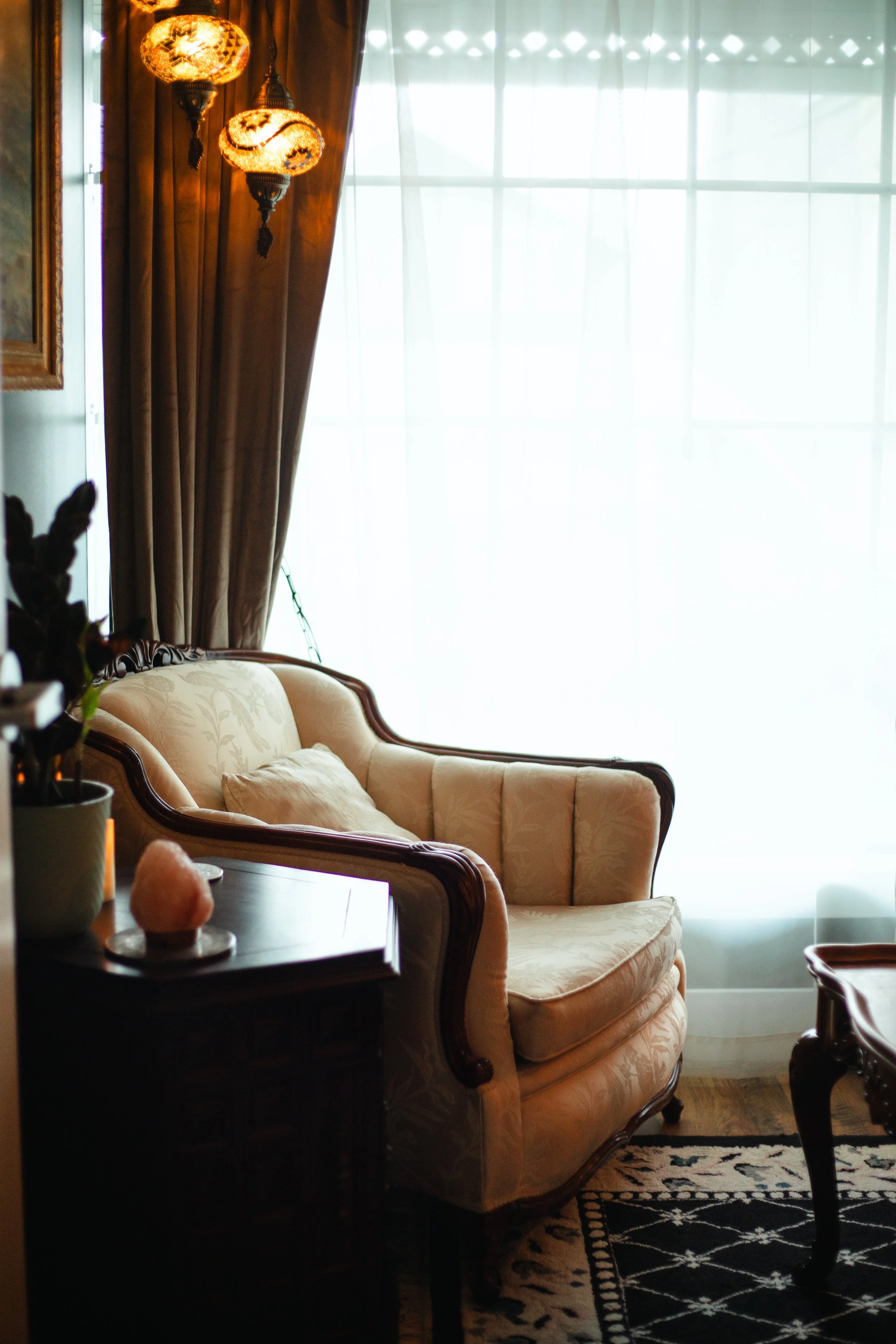 Calm counselling room with a vintage armchair and soft natural light at The Den Wellness Collective in Vancouver