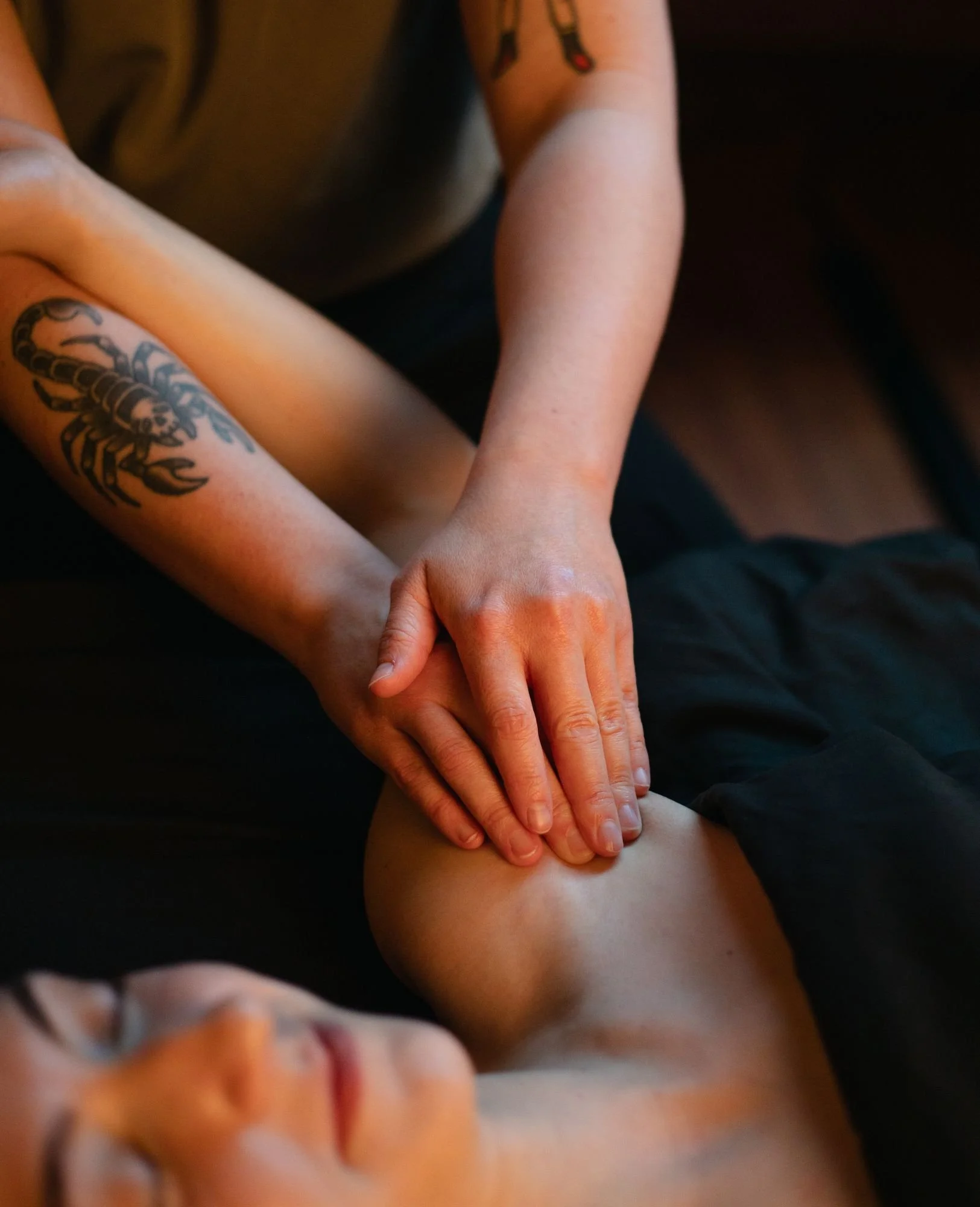 Registered massage therapist working on a client's shoulder at The Den Wellness Collective in Vancouver