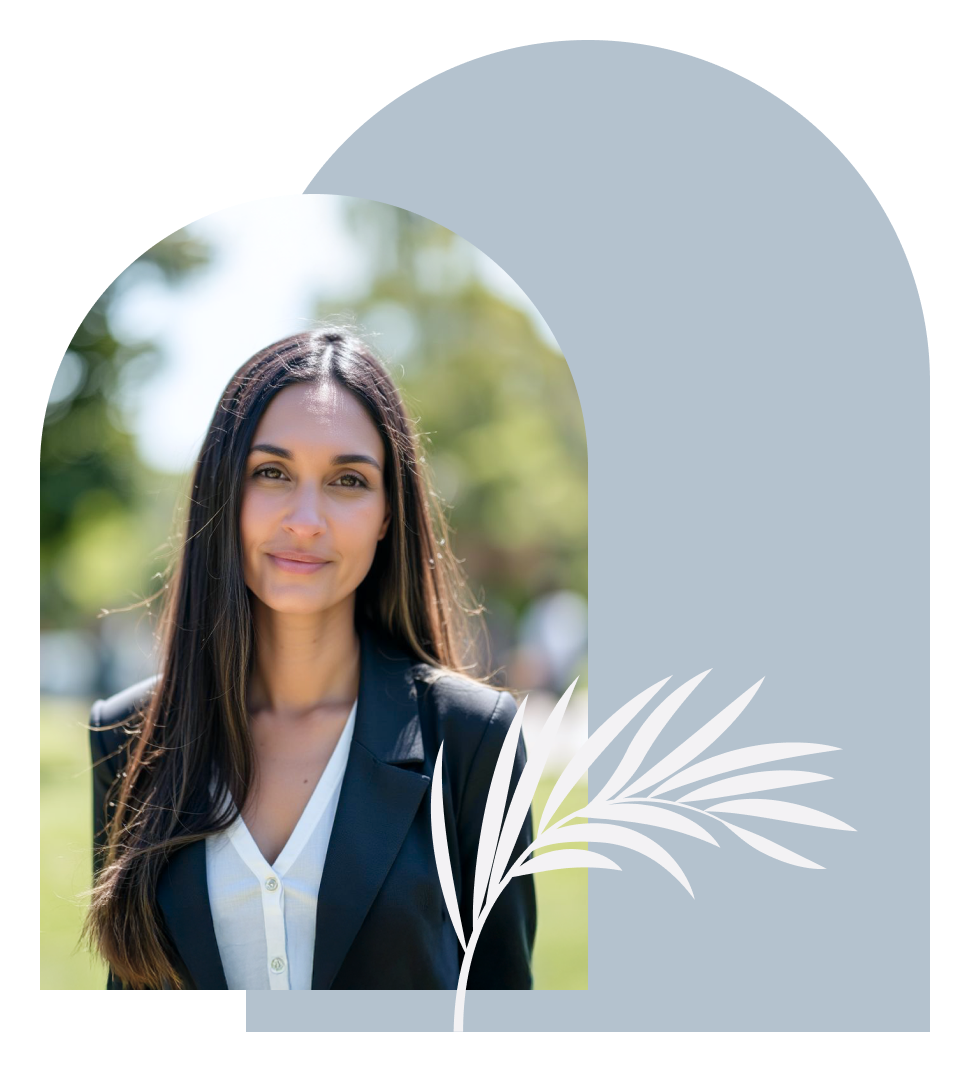 A woman with long dark hair and a medium skin tone is smiling outdoors, wearing a black blazer over a white shirt, with a blurred background of trees and sunlight. She appears warm, calm, professional, grounded.