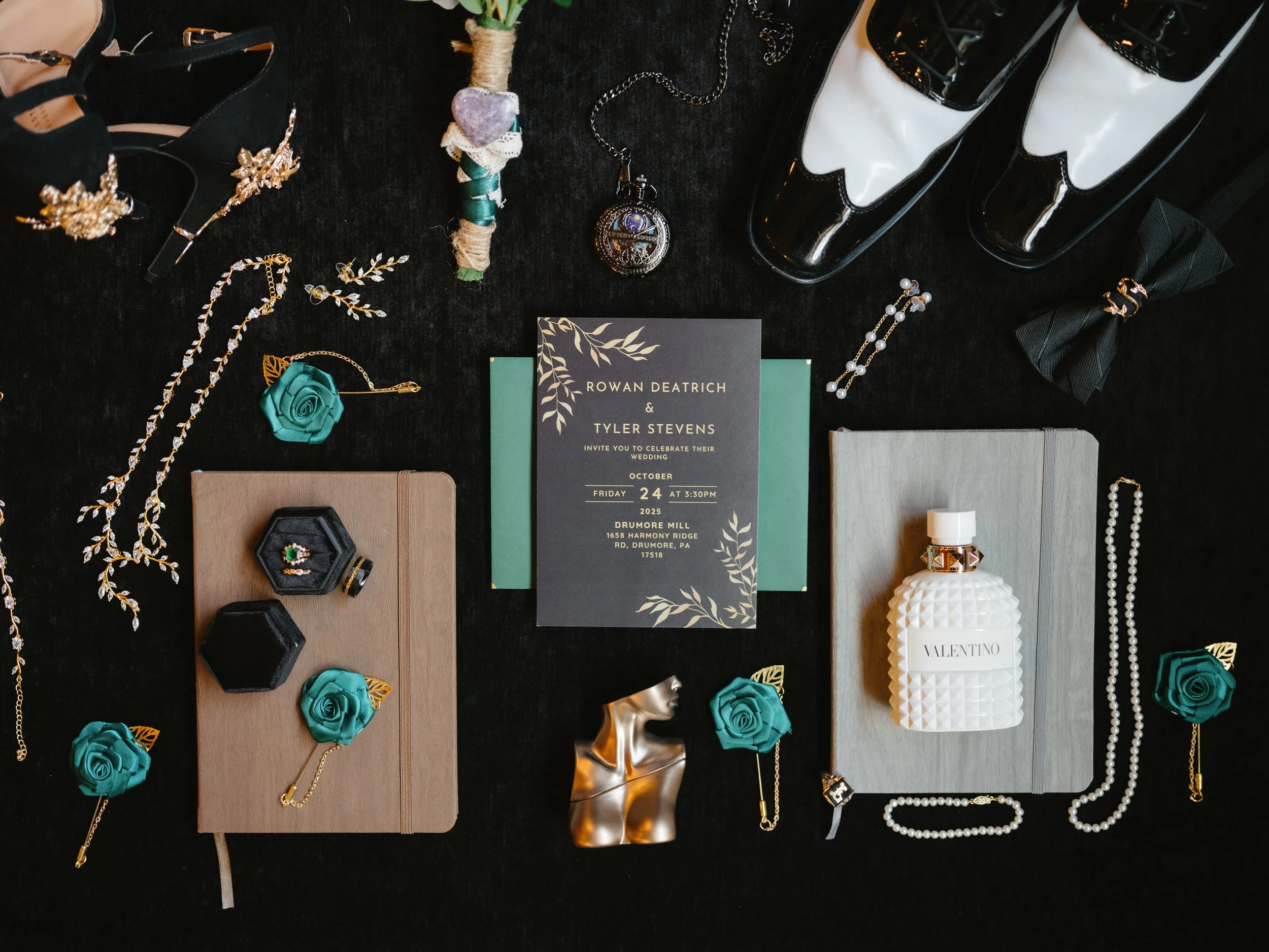 Wedding invitation surrounded by jewelry, shoes, perfume, and accessories on a black surface.