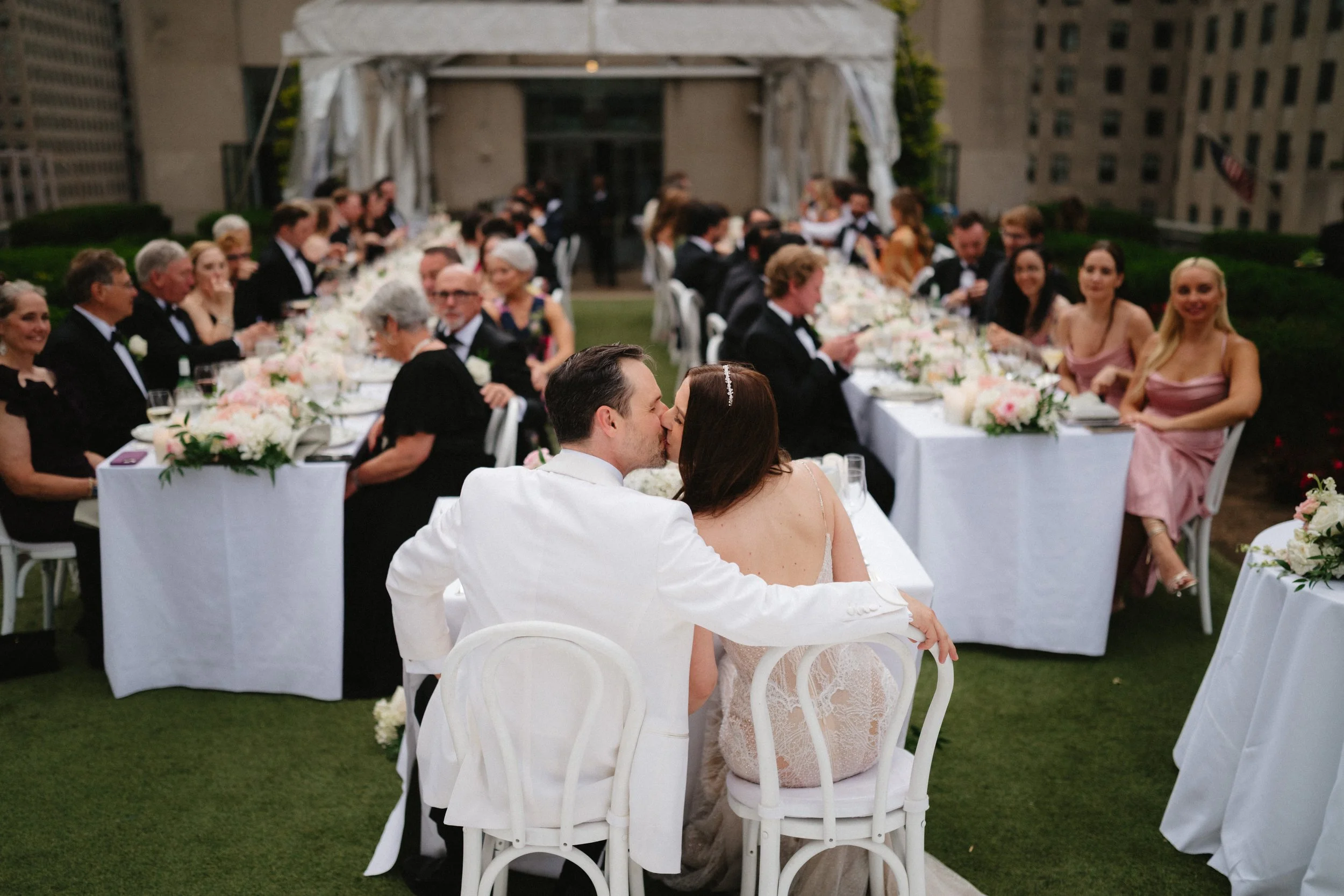 Bride and groom smiling while holding glasses inside a car