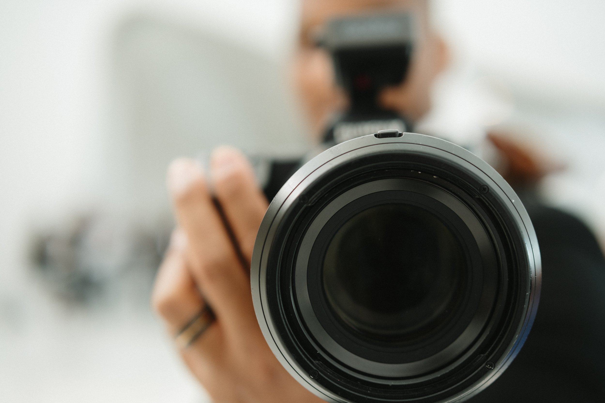 Wedding Photographer holding a camera pointed at a mirror, capturing their reflection.