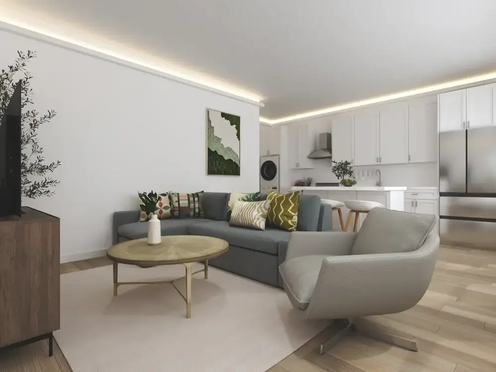 Backyard ADU Modern living room with kitchen, featuring a gray sofa, armchair, wooden coffee table, white cabinetry, stainless steel appliances, and decorative plants and artwork.