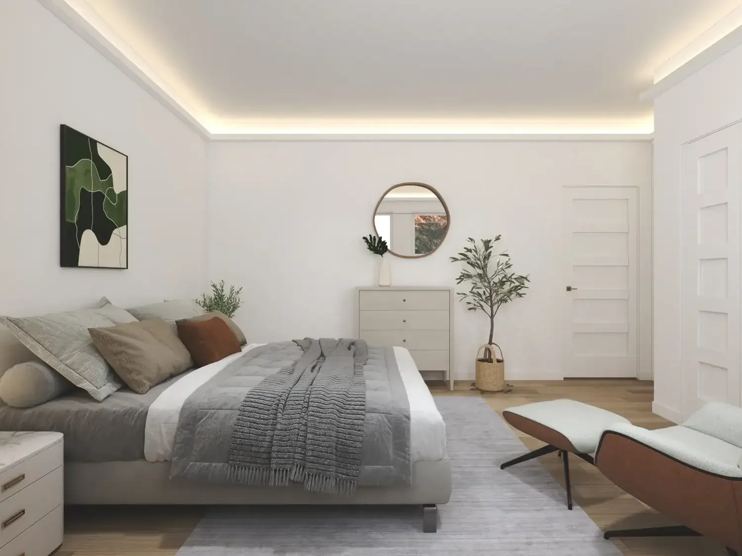 Backyard ADU Modern bedroom interior with white walls, a bed with gray and brown pillows, gray bedspread, abstract green wall art, circular mirror above a dresser, a potted plant, and a lounge chair with ottoman.