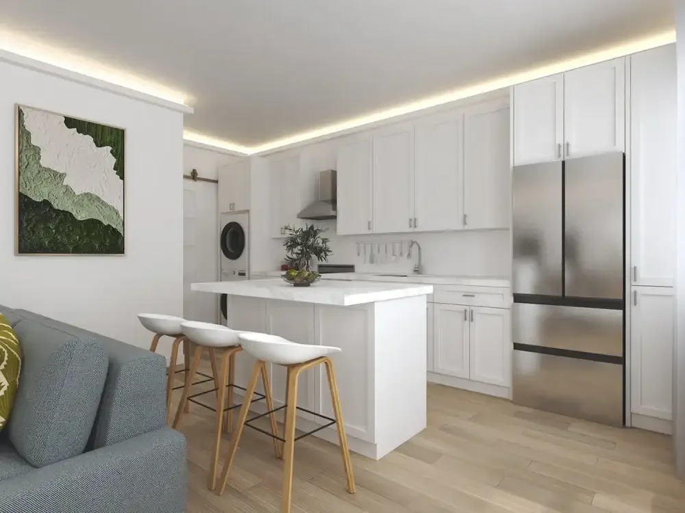 Backyard ADU Modern kitchen with white cabinets, marble island, bar stools, stainless steel refrigerator, washing machine, and decorative wall art.