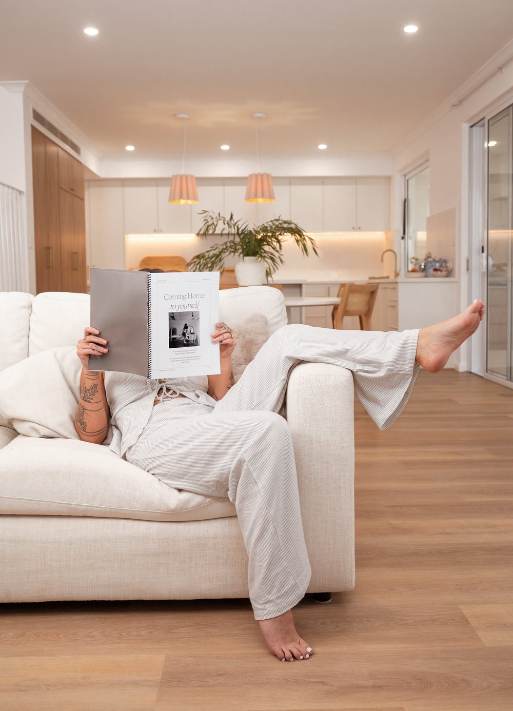 Pania reading the Coming Home to Yourself workbook on the couch