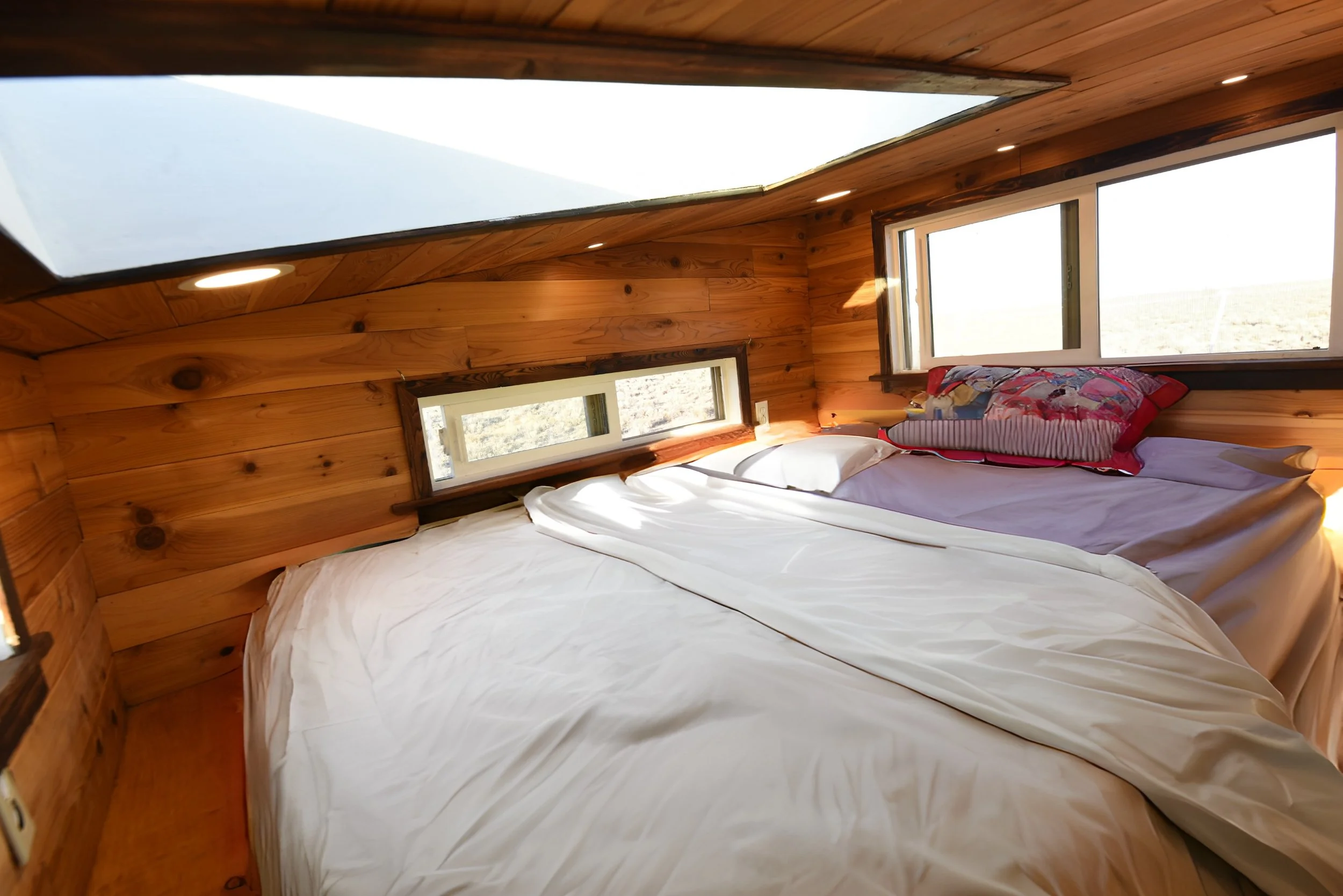 White bed in tiny house loft