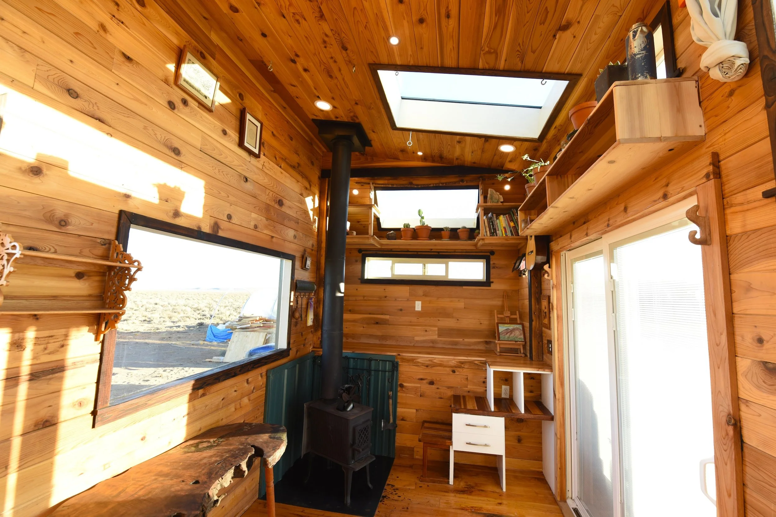 Tiny house living room with wood stove and many windows