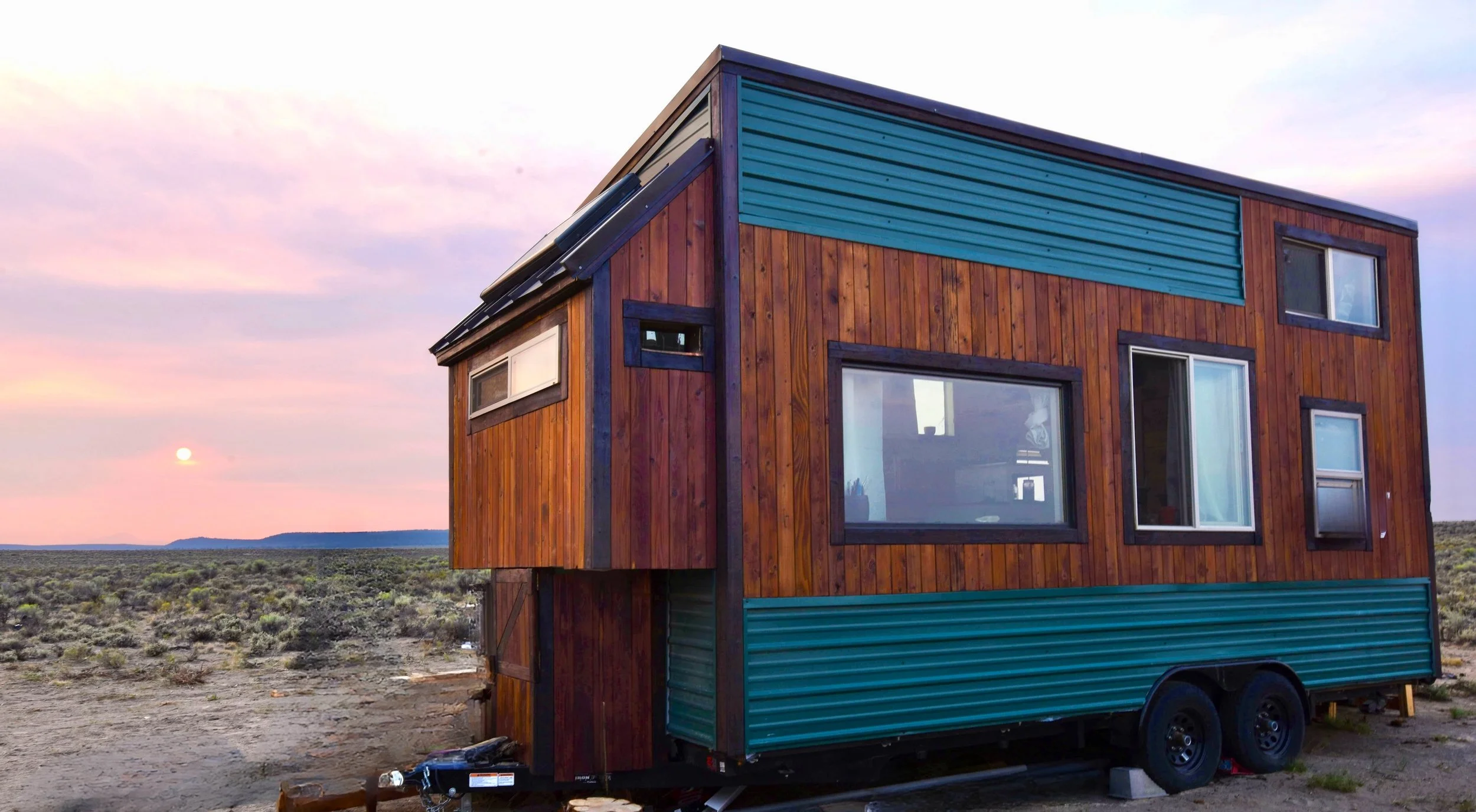 Tiny house in badlands with sun setting