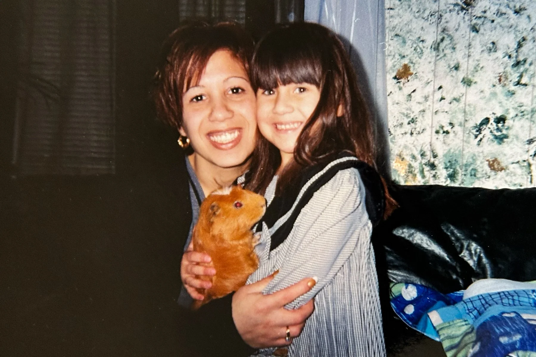 Childhood photo of Lexis and her mother holding a guinea pig, representing treasured memories with beloved pets.