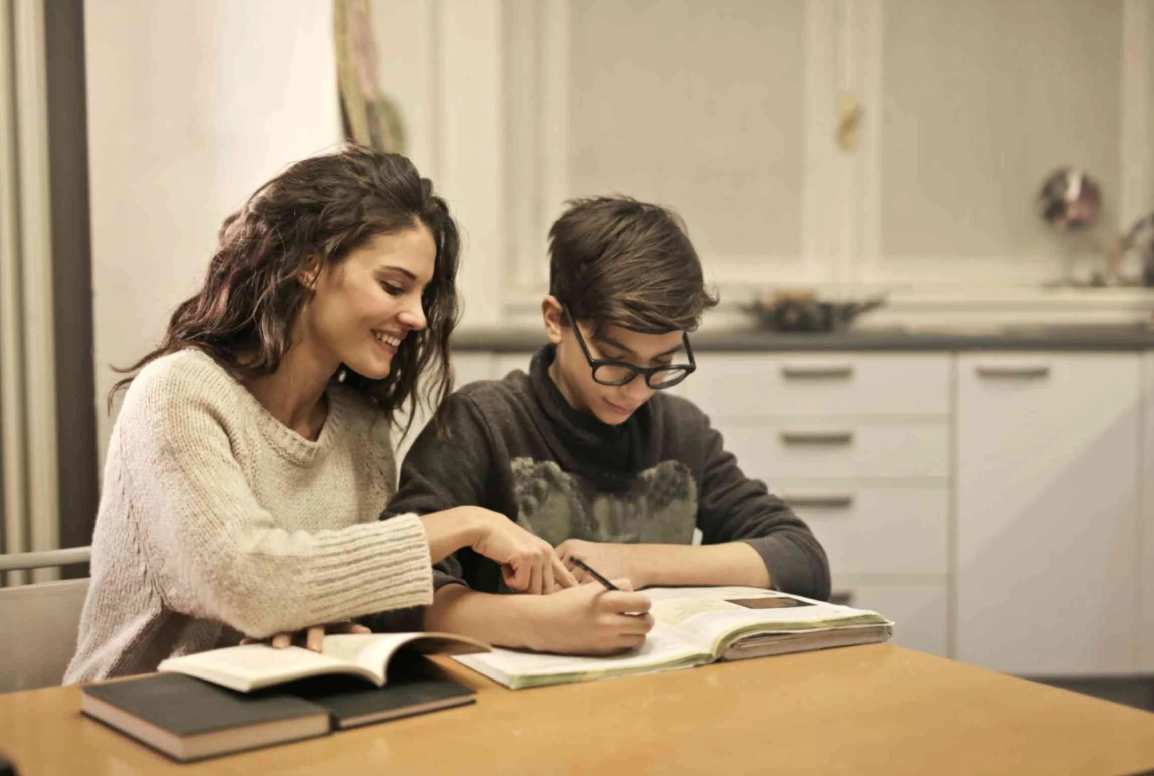 Boy studying with a tutor at a table during a focused learning session