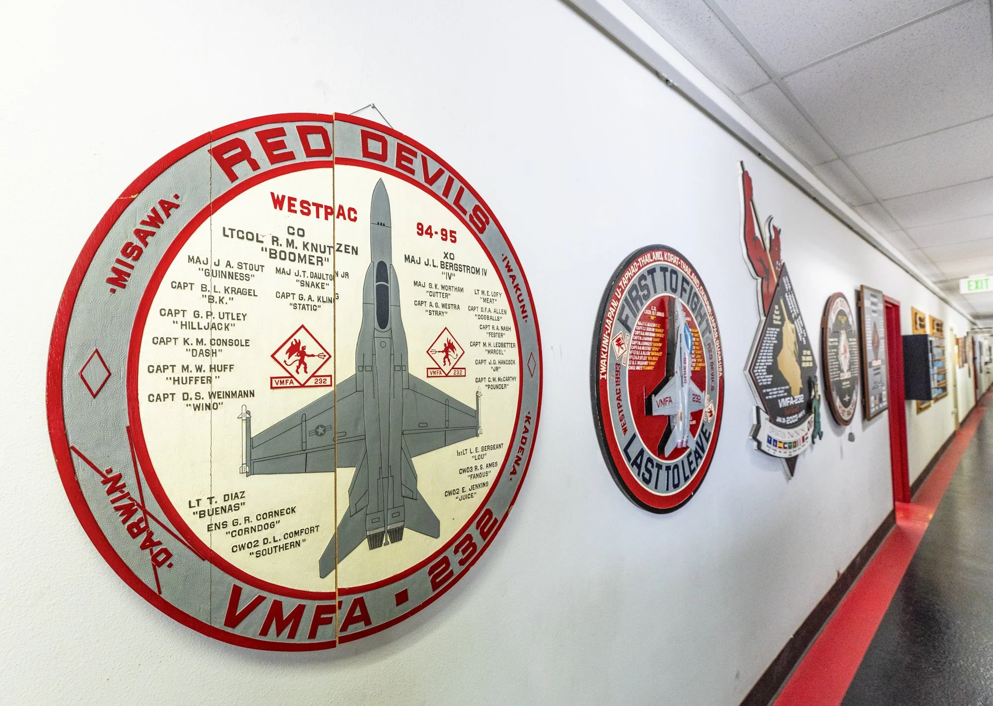 Wall display with vintage military patches and a large circular badge featuring a fighter jet, related to the Red Devils Wing of the Missouri Air National Guard.