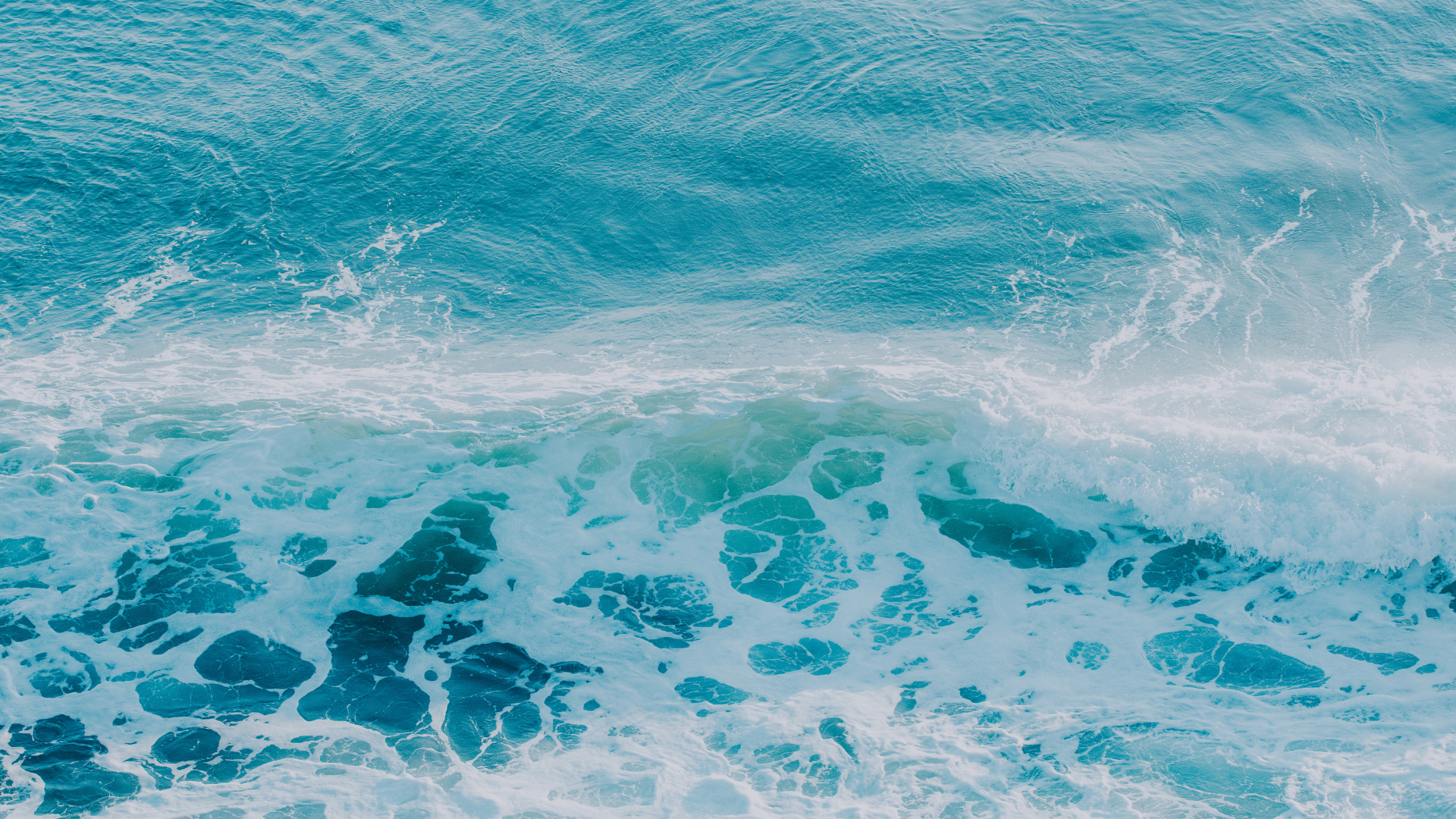 Ocean waves with white foam crashing and turquoise water