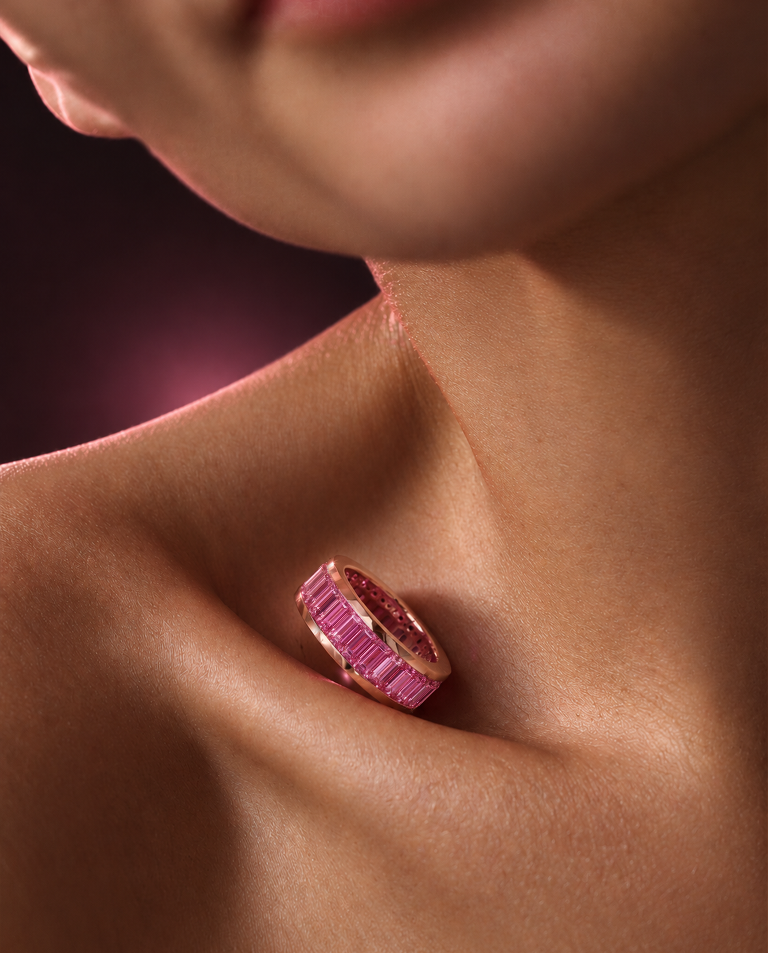 Close-up editorial view of the INFINÉ Pink Sapphire Ring showing its continuous pink sapphire channel setting and rose gold edges.