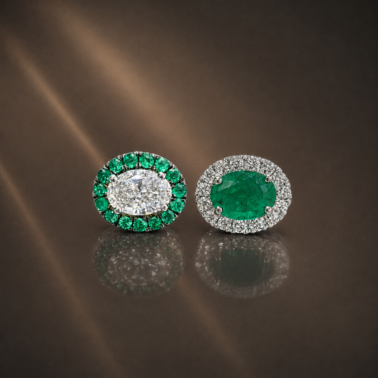 Pair of circular earrings with large central green gemstones surrounded by smaller clear and green stones, placed on a reflective dark surface.