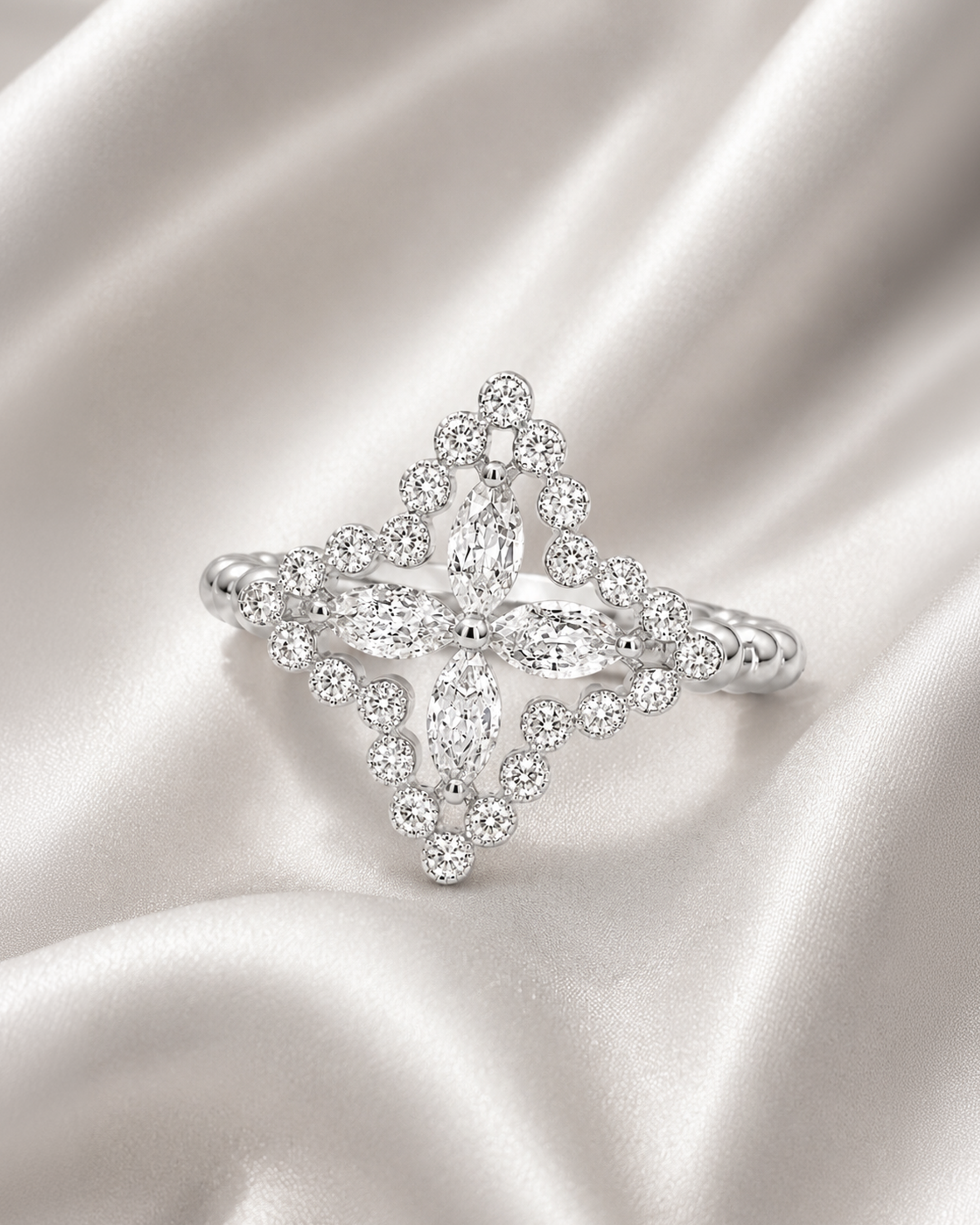 Close-up of a diamond ring and earrings displayed on silky white fabric.
