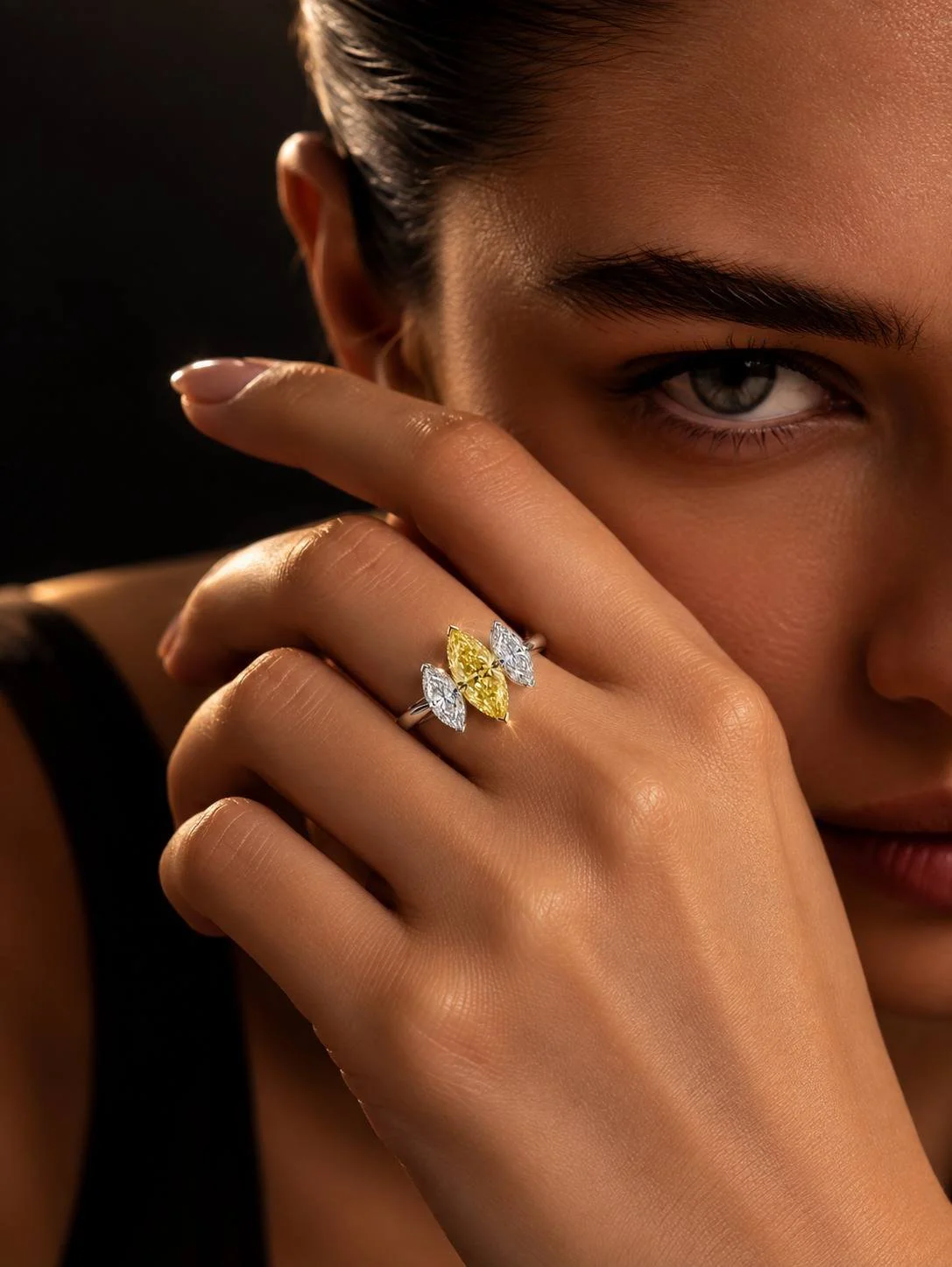 SUNÉ Marquise ring worn on the hand, showing the Fancy Yellow marquise center diamond between two natural white marquise diamonds.