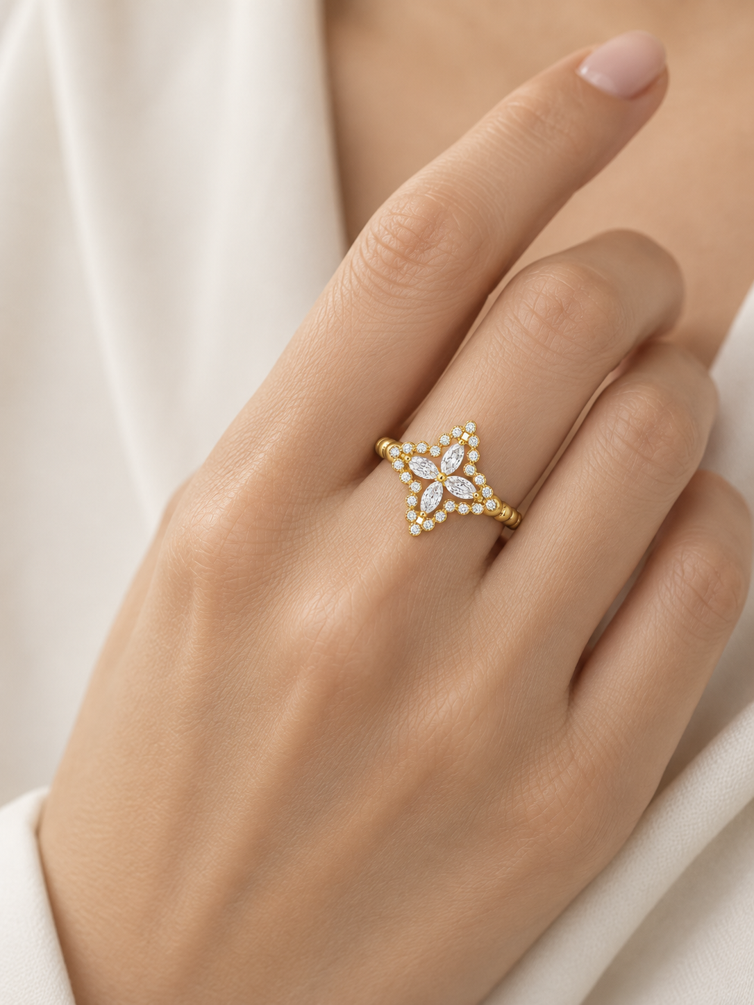 AIR Marquise Flower Ring in yellow gold worn on the hand, showing its four-petal diamond design and scale.