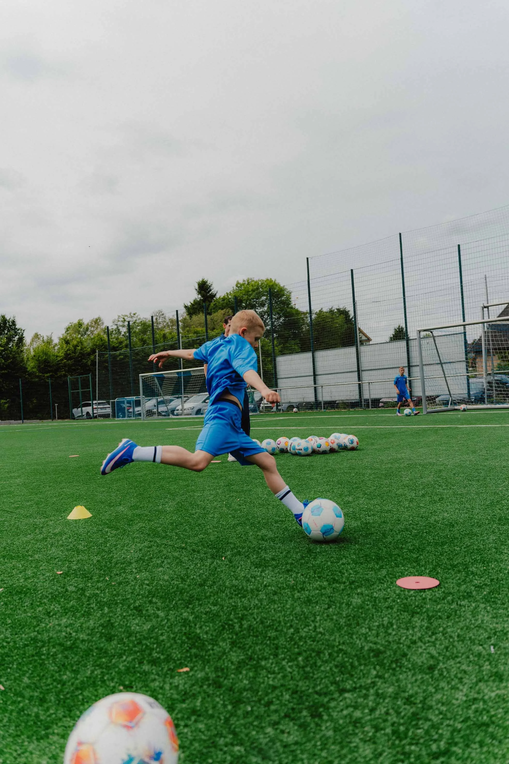 Kind mit Fußball beim Torabschluss