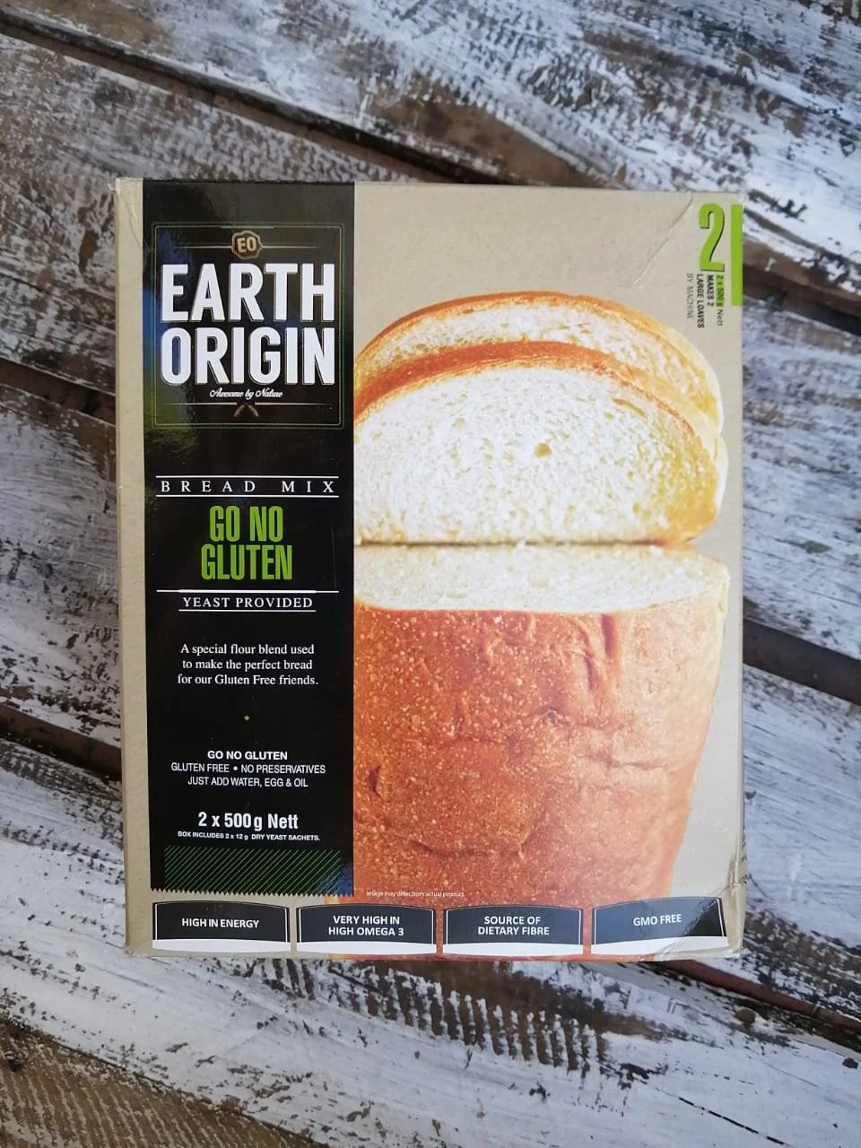Box of Earth Origin gluten-free bread mix with a sliced bread roll on the front, placed on a wooden surface.
