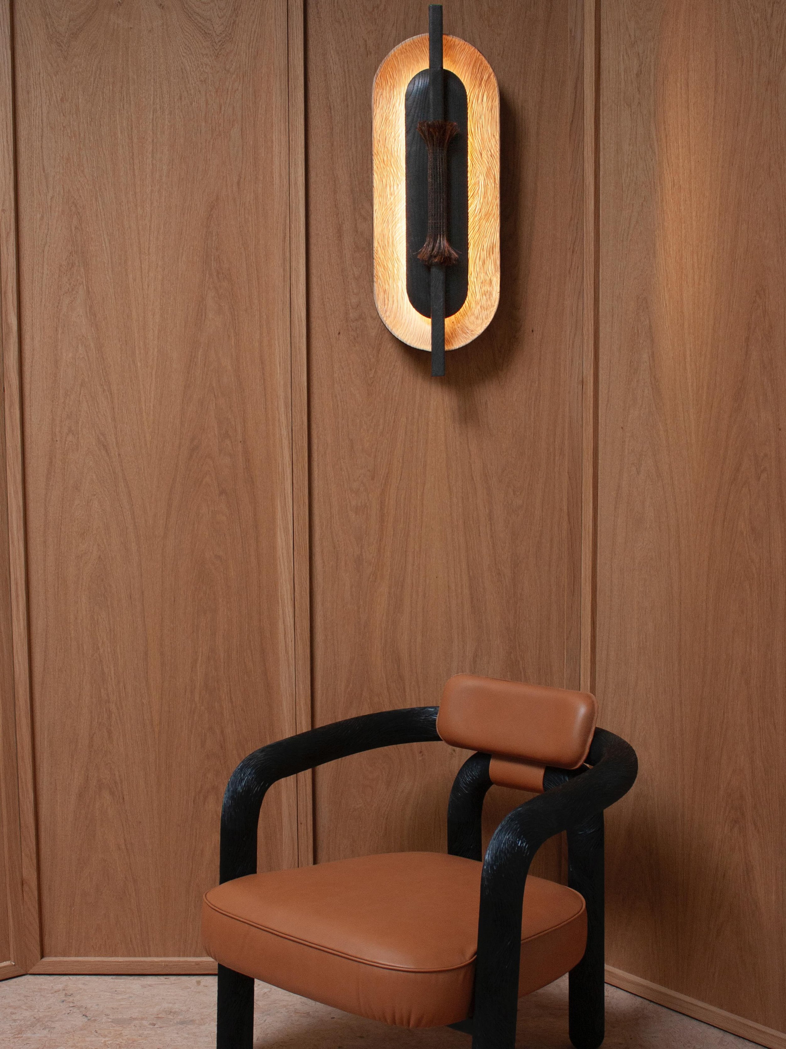 Applique Olono et fauteuil Faune, motif sculpt&eacute; &agrave; la main inspir&eacute; du mouvement de la fourrure. 

Olono wall sconce and Faune armchair, featuring a hand-carved pattern inspired by the fluid movement of fur.
