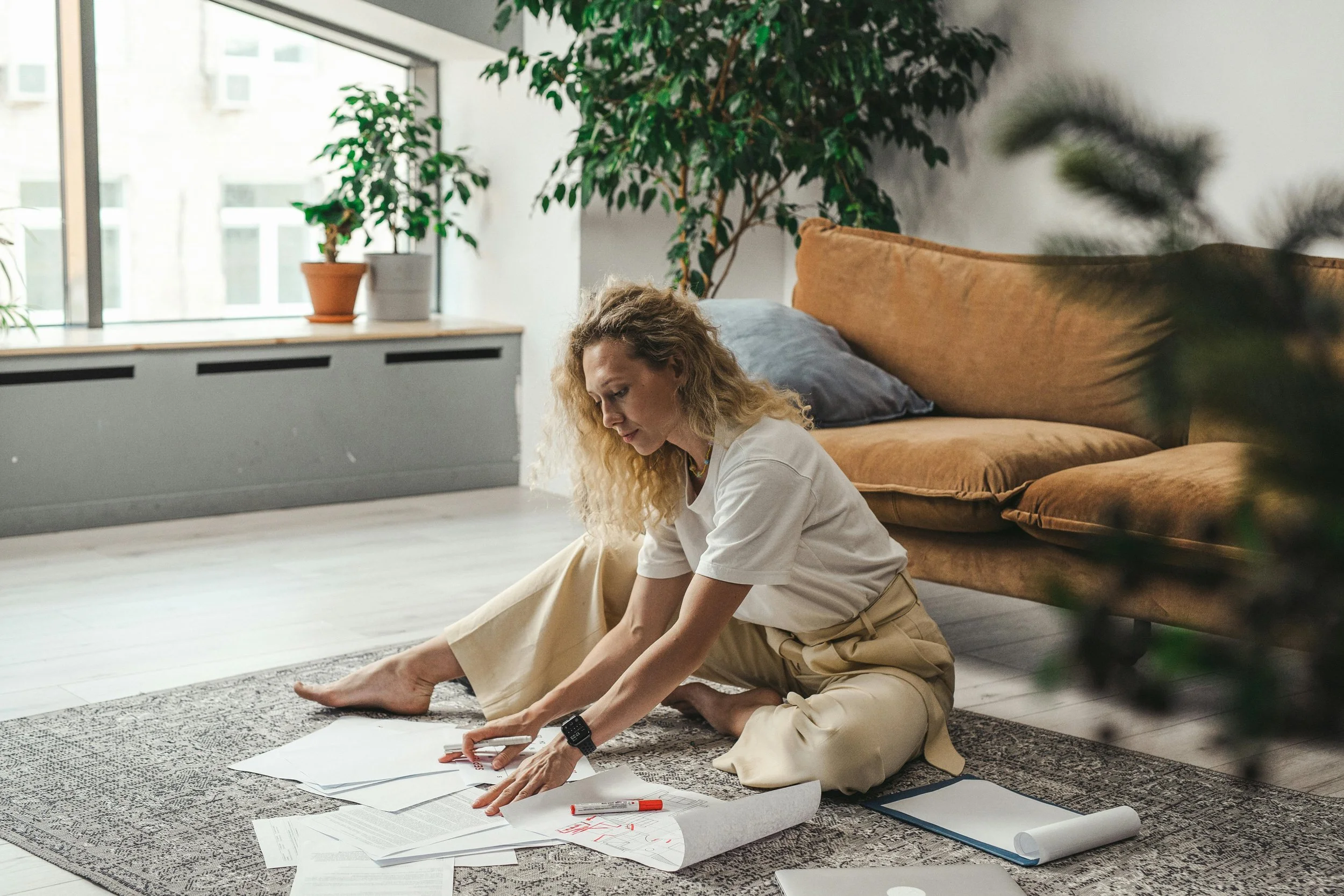 Woman journaling on floor during therapy intensive session in calming space.
