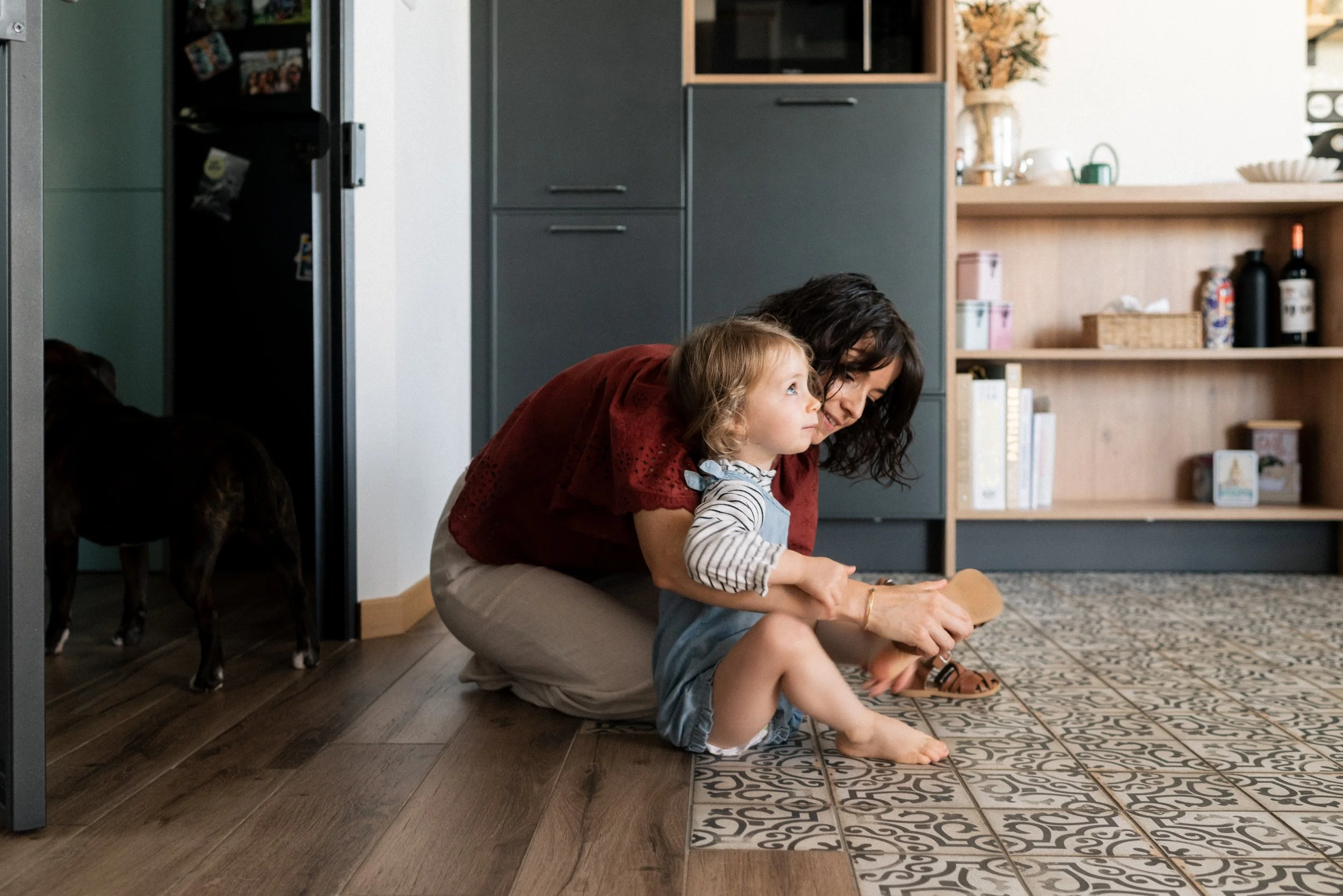 Une enfant met ses chaussures à Nantes aidé par sa maman