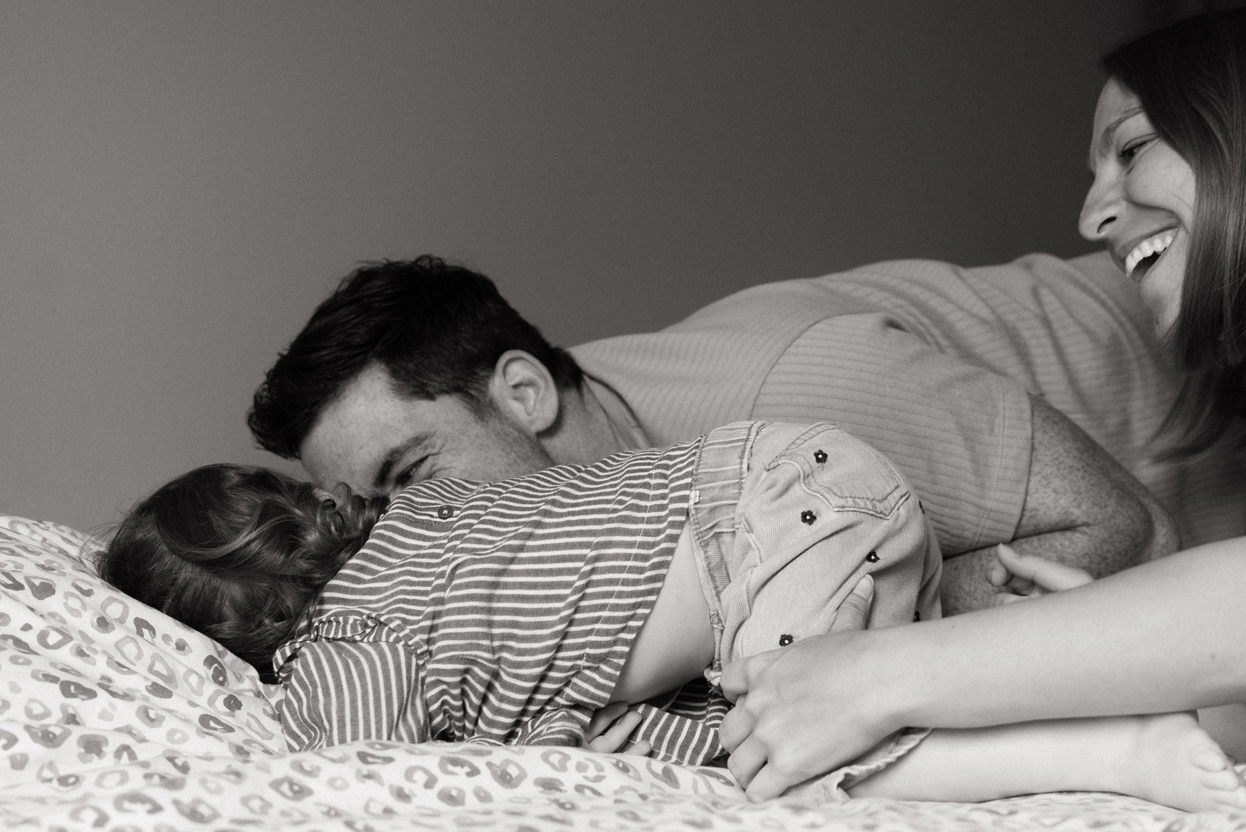 les regards souriants d'une famille sur un lit